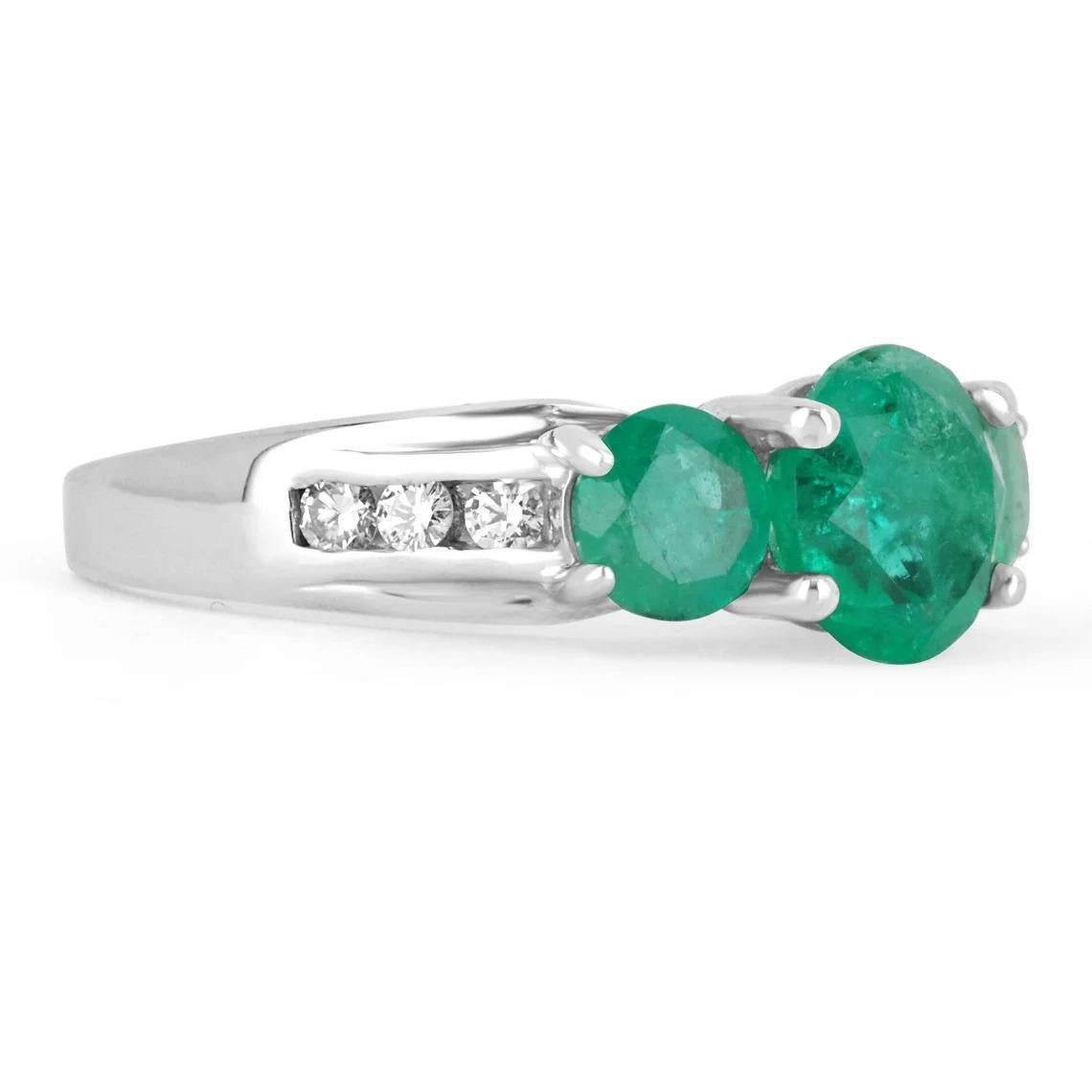 Elegantly displayed is a gorgeous three-stone round emerald and diamond accent engagement ring. This romantic engagement ring is captivating from every angle. The brilliant round Colombian emeralds are medium-dark deep green and have very good