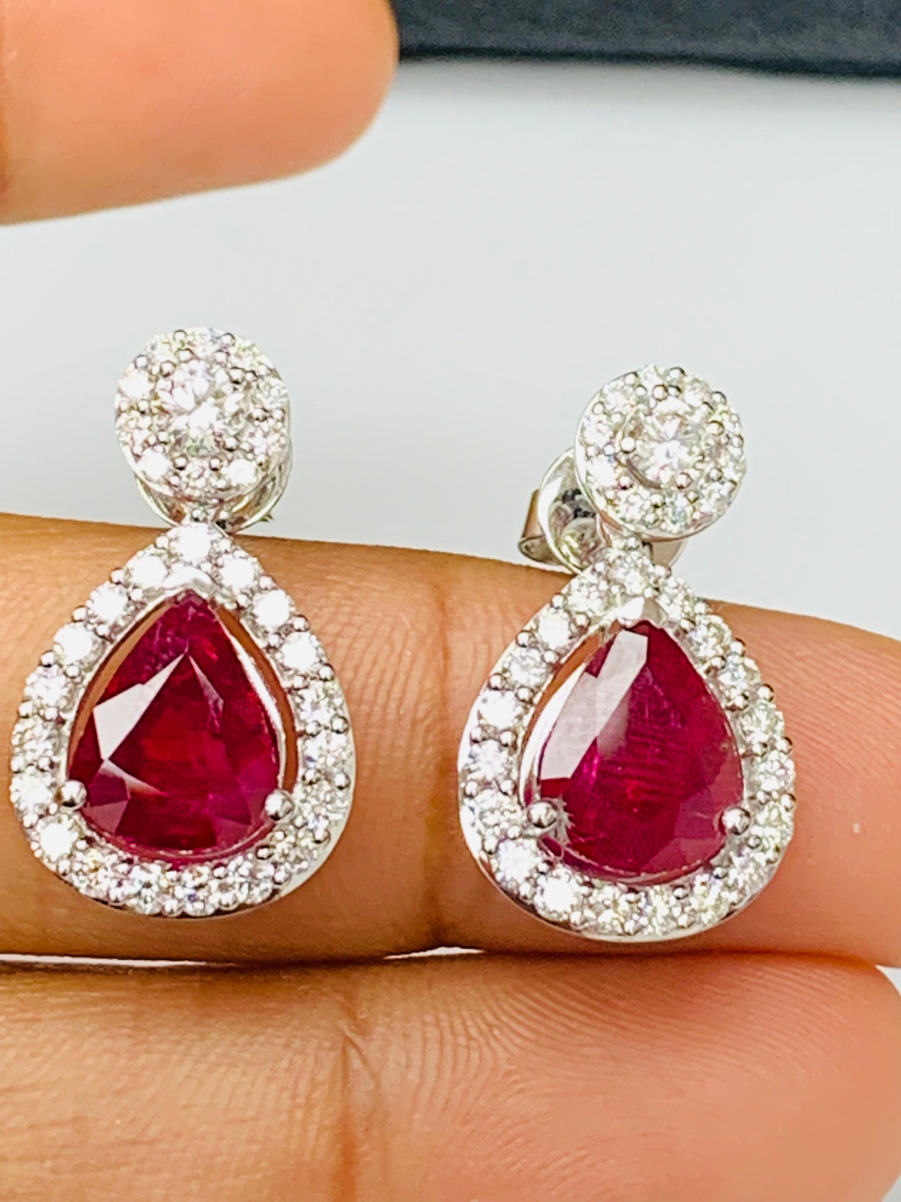 A beautiful and chic pair of drop earrings showcasing brilliant-cut diamonds, and pear shape Rubies set in an intricate and stylish design. 2  Diamonds on the top weigh 0.38 carats in total.  2 pear shape rubies weigh 3.56 carats in total. Made in