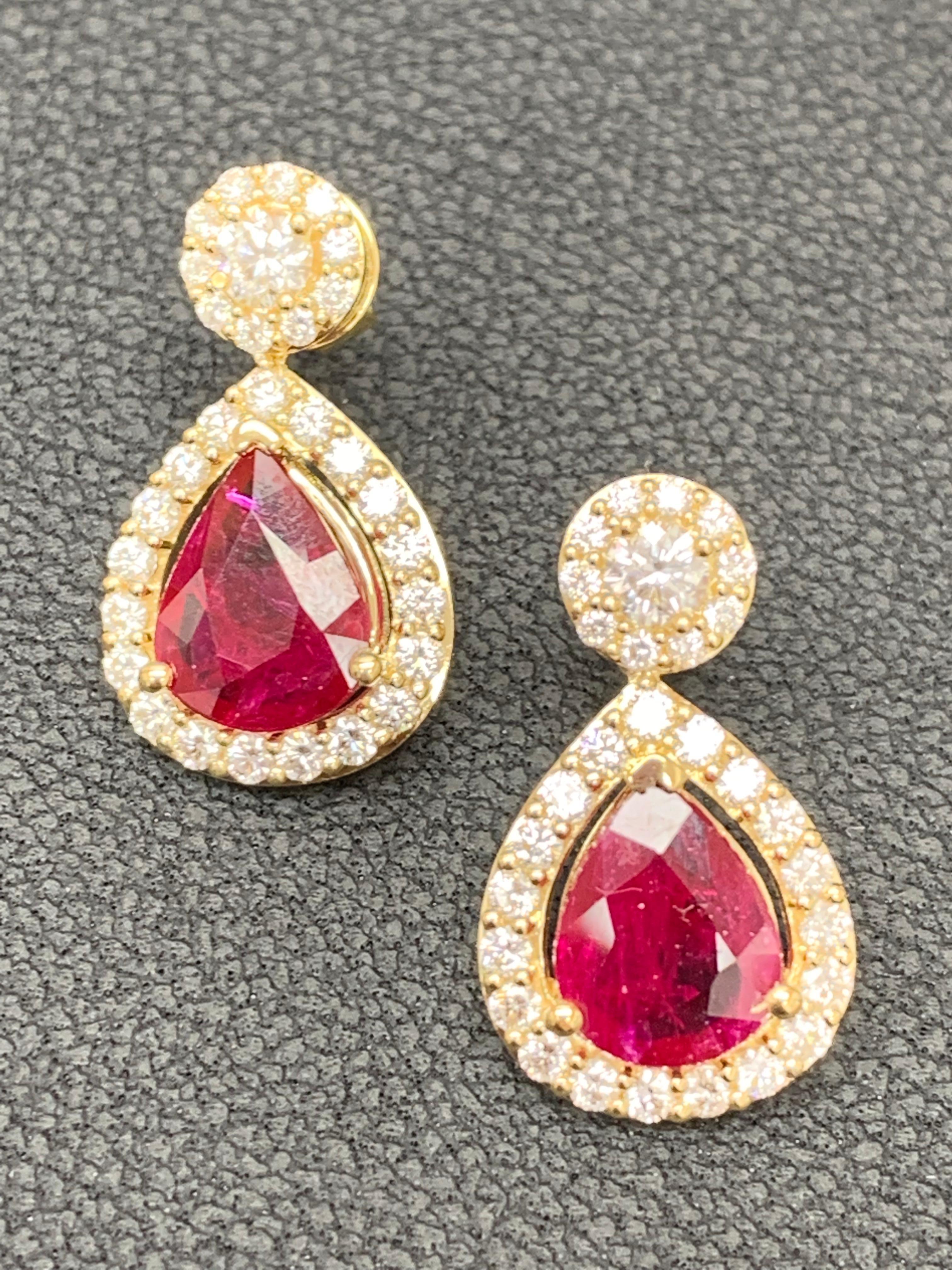 A beautiful and chic pair of drop earrings showcasing brilliant-cut diamonds, and pear shape Rubies set in an intricate and stylish design. 2 Diamonds on the top weigh 0.38 carats in total.  2 pear shape rubies weigh 3.56 carats in total. Made in