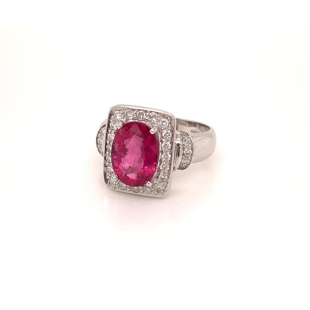 This Gorgeous ring features a Luxurious Oval Cut Rubellite Tourmaline Stone weighing approximately 3.56 Carats and is claw set in 18K White Gold with Glimmering Round Brilliant Diamonds weighing approximately 0.51 Carats in a Classic style. This