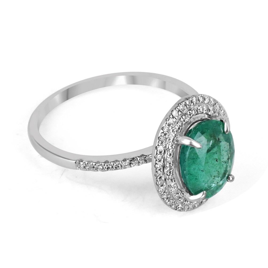Featured is a stunning emerald and diamond ring. The center gemstone showcases a beautiful 3.16-carat, natural oval cut emerald from the origin of Zambia. Displaying a gorgeous and lush dark green color. This emerald is very good clarity with minor