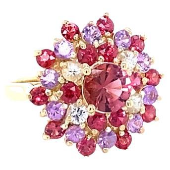 This Ring has a pretty Round Cut Tourmaline in the center that weighs 0.87 Carats.  The Tourmaline is surrounded by 30 Multi Sapphires that create a flower like design.  The Multi Sapphires weigh 2.70 carats and the total carat weight of the ring is