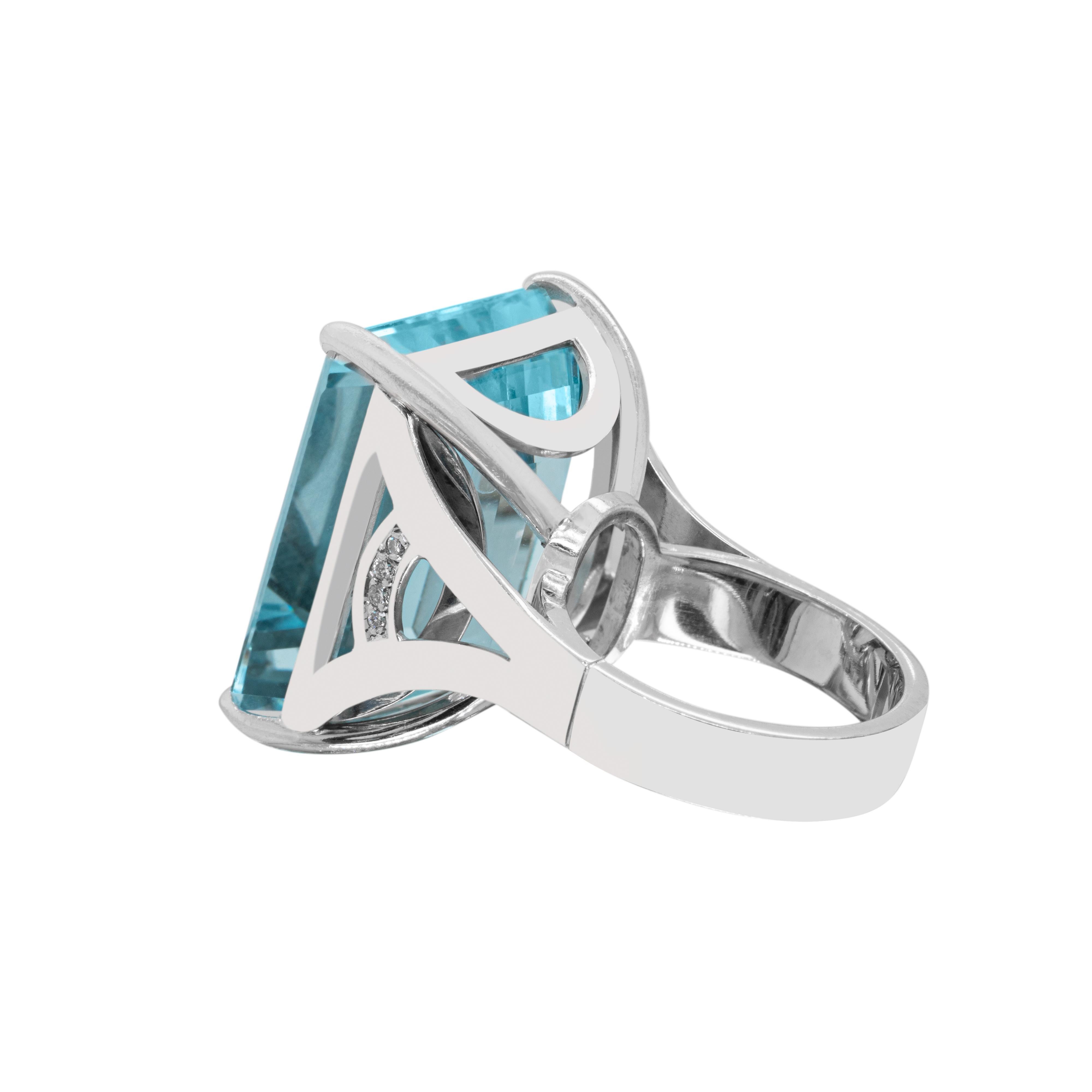 This magnificent ring features a vibrant emerald cut aquamarine weighing an impressive 35.72 carats mounted in a four claw, open back setting. The gallery is set with 4 round brilliant cut diamonds on either side of the aquamarine weighing