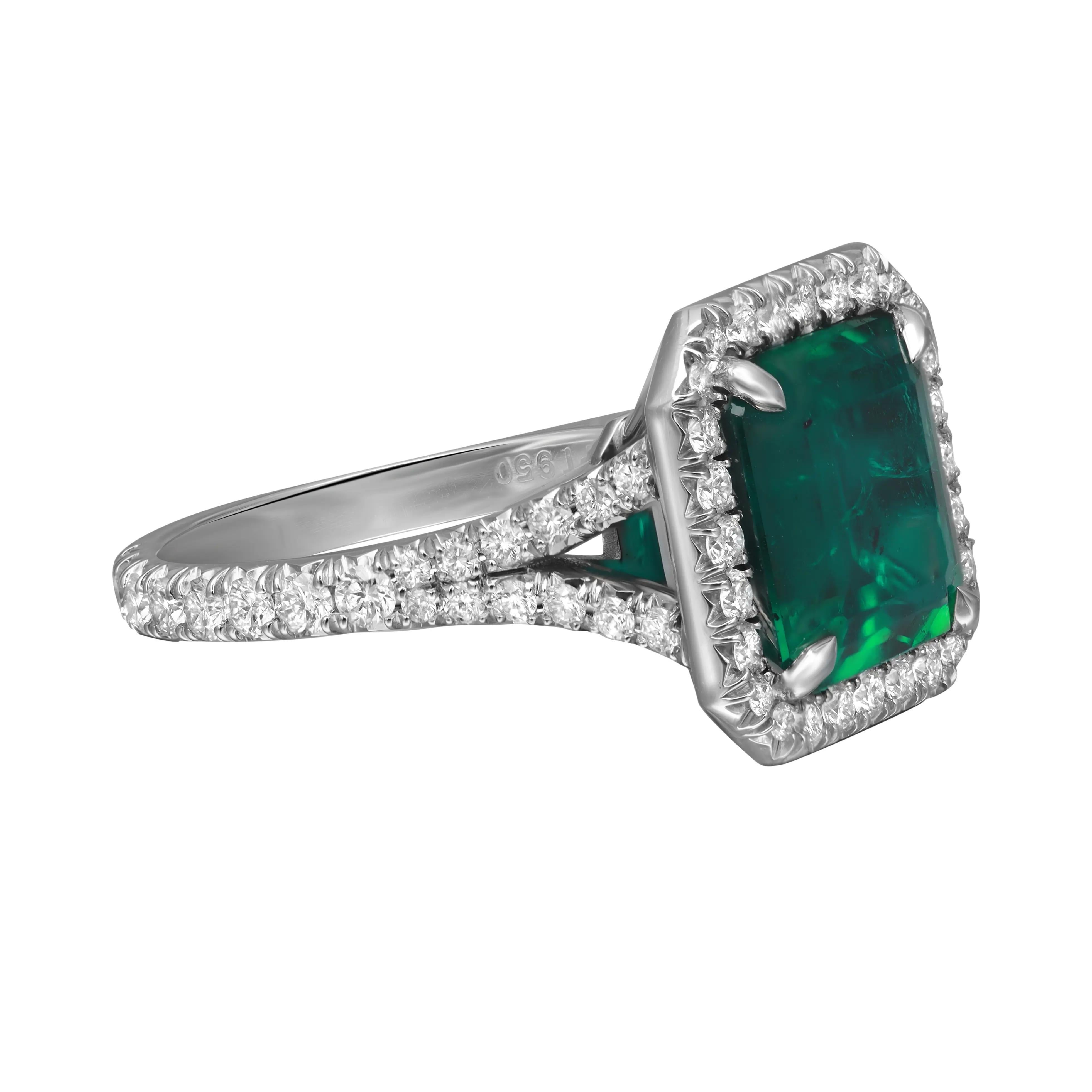 This breathtaking engagement ring features a beautiful GIA Certified 3.57 carats of octagonal Zambian green Emerald as the centerpiece with 0.90 carat of round brilliant cut diamond accents surrounding the gem in a sparkling halo setting and