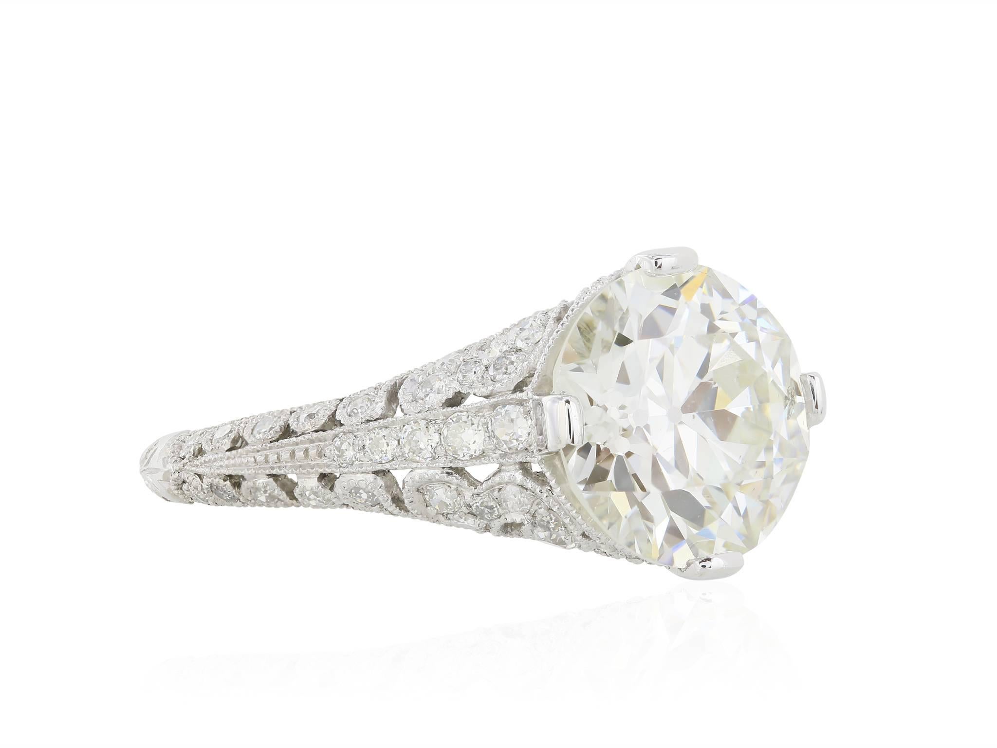 Platinum antique style mounting with .57 carats of round brilliant cut diamonds set in a scrollwork styling.  The ring features an approximately 3.58 carat old European cut diamond center stone with a color of J and a clarity of SI1.