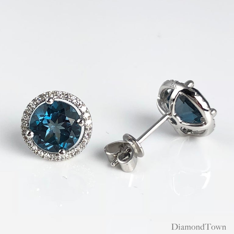 These stunning halo stud earrings feature 3.58 carats London Blue Topaz, surrounded by a halo of round white diamonds.

Center: two round London Blue Topaz stones total 3.58 carats
Diamond Halo: 56 round diamonds total 0.16 carats
Set in 14k White