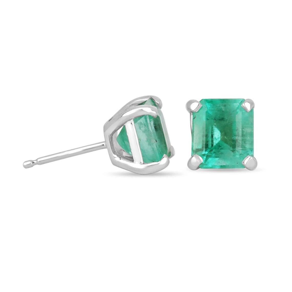 A classic pair of Asscher-cut green natural rare Colombian emerald hand-made gold studs in solid 14K white gold. These rare earrings feature two bluish sea green, natural earth mined Colombian emeralds that are handset in a single four-prong