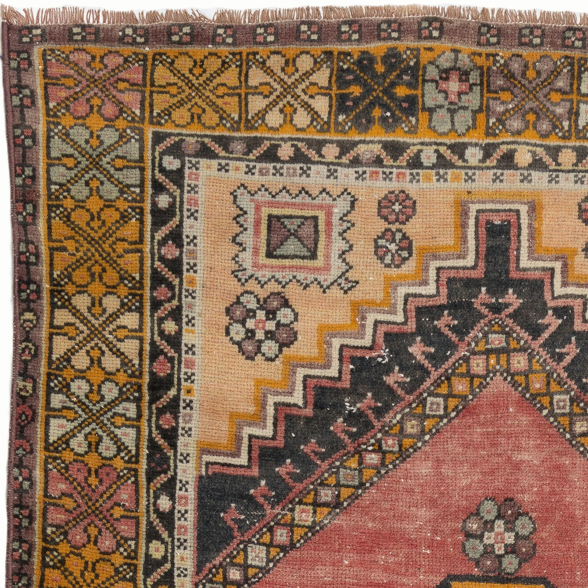 A vintage hand-knotted Turkish village rug with medium wool pile on wool foundation. It features a geometrical medallion at its center and large corner pieces filled with tribal motifs as well as a border decorated with angular star motifs. The rug