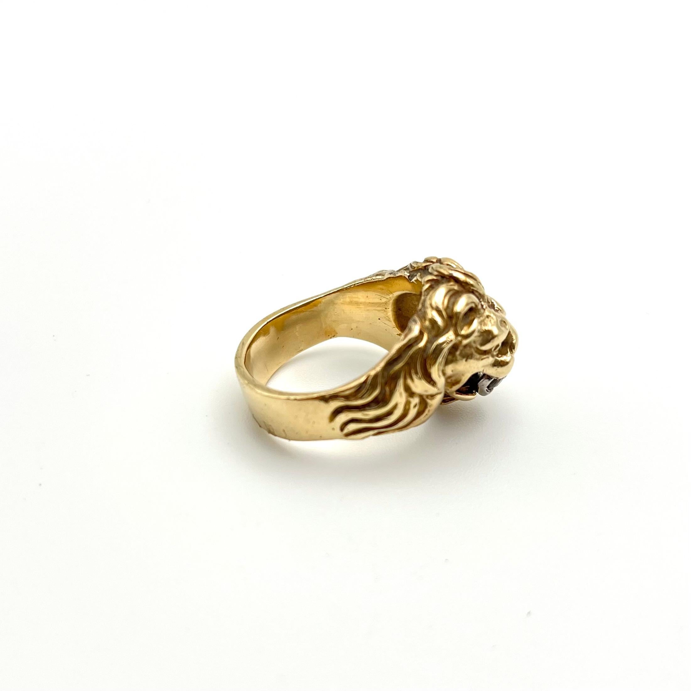 Questo anello vintage da uomo è realizzato in oro giallo massiccio a 14 carati. La testa e i rebbi in oro bianco trattengono un diamante rotondo da .36 carati nella bocca del leone. Abbiamo classificato il diamante come SI1 per la purezza e I per il