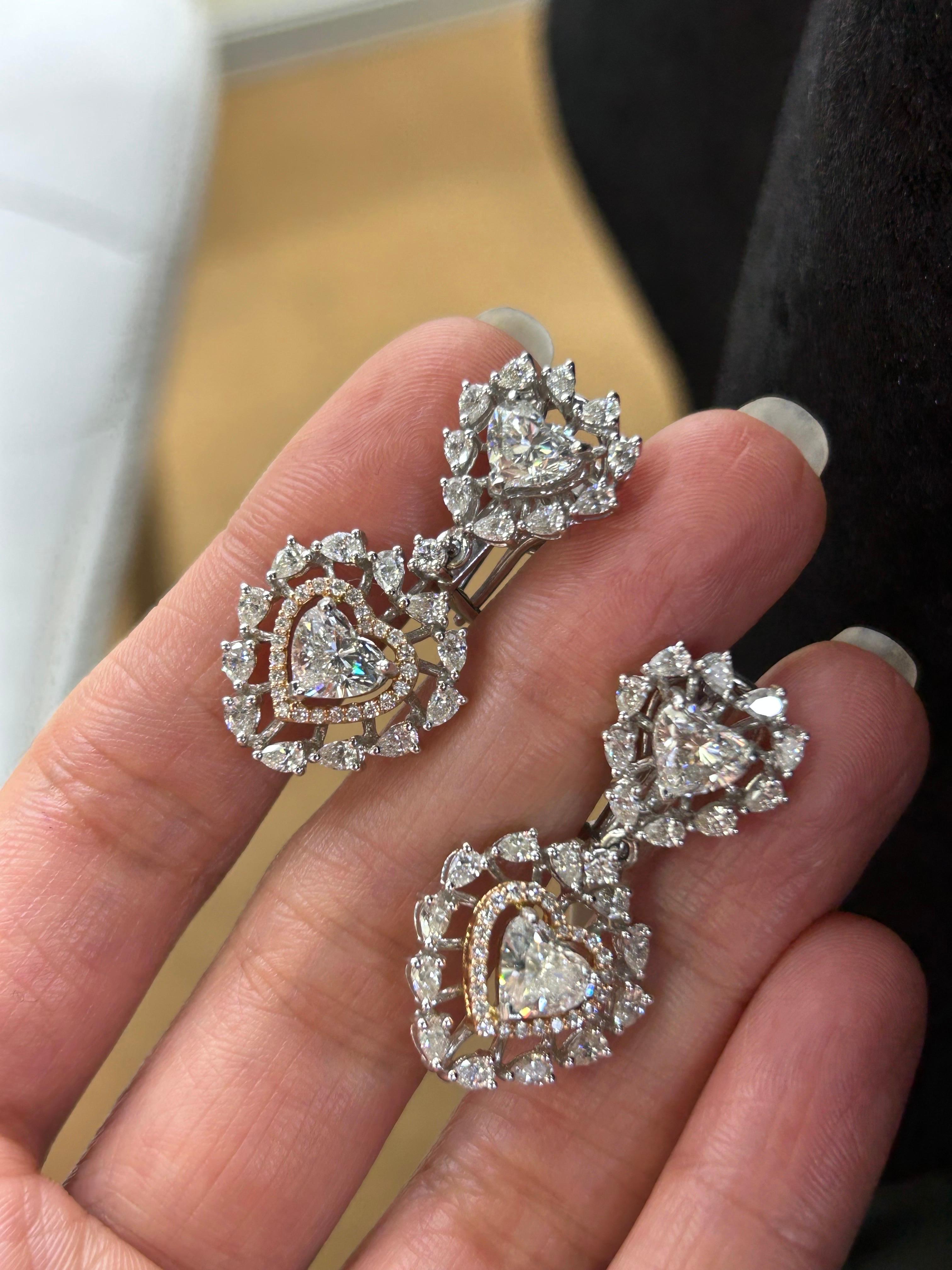 A beautiful 3.6 carat Heart Shape Diamond dangle earrings, G.H color SI quality, with around 1.5 carat pear and round shape diamonds surrounding it. All set in solid 18K White Gold. 