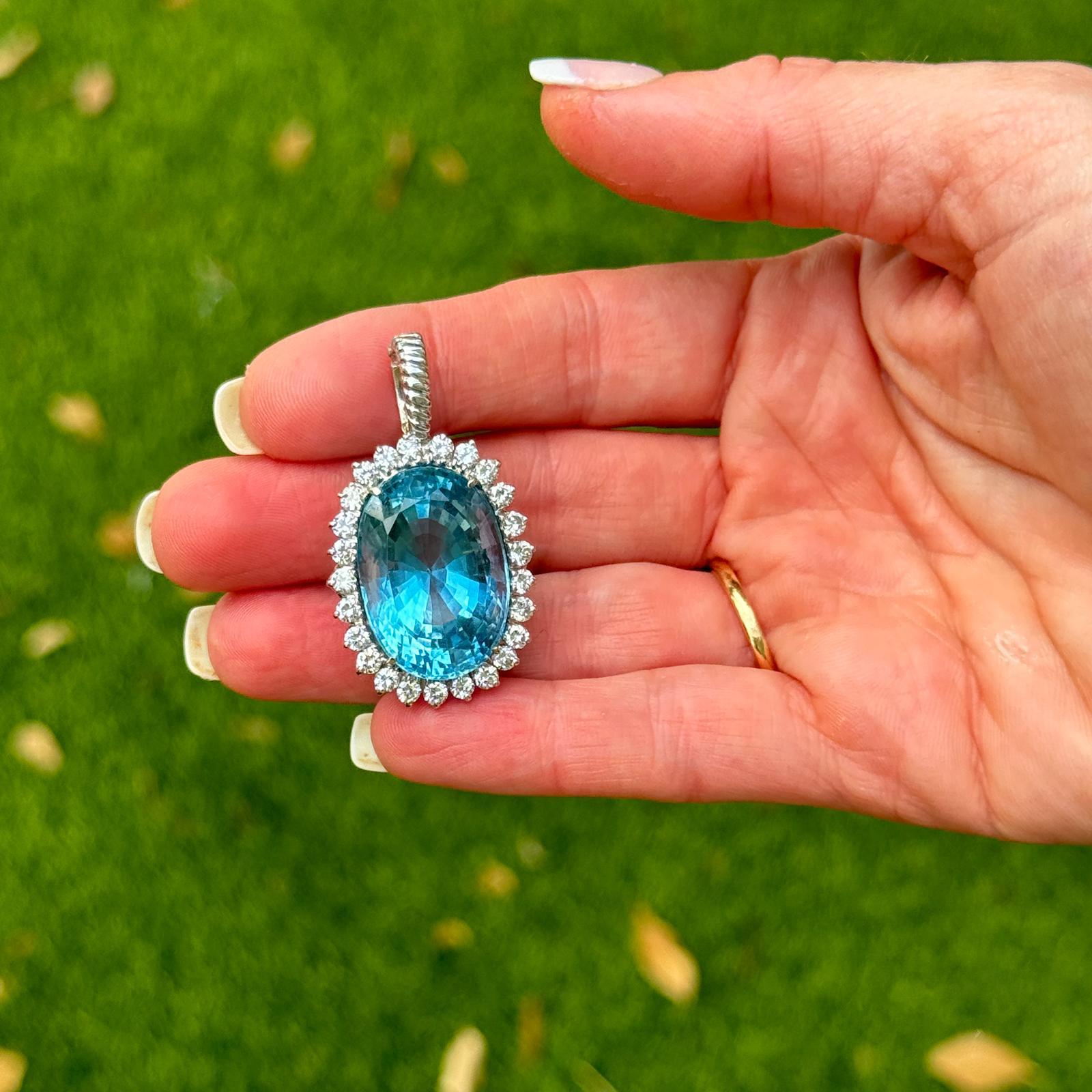 This modern 36-carat oval blue topaz diamond pendant is a striking piece of contemporary jewelry that combines bold gemstone elegance with the timeless sparkle of diamonds.
At the heart of the pendant is a sizable 36-carat oval blue topaz gemstone
