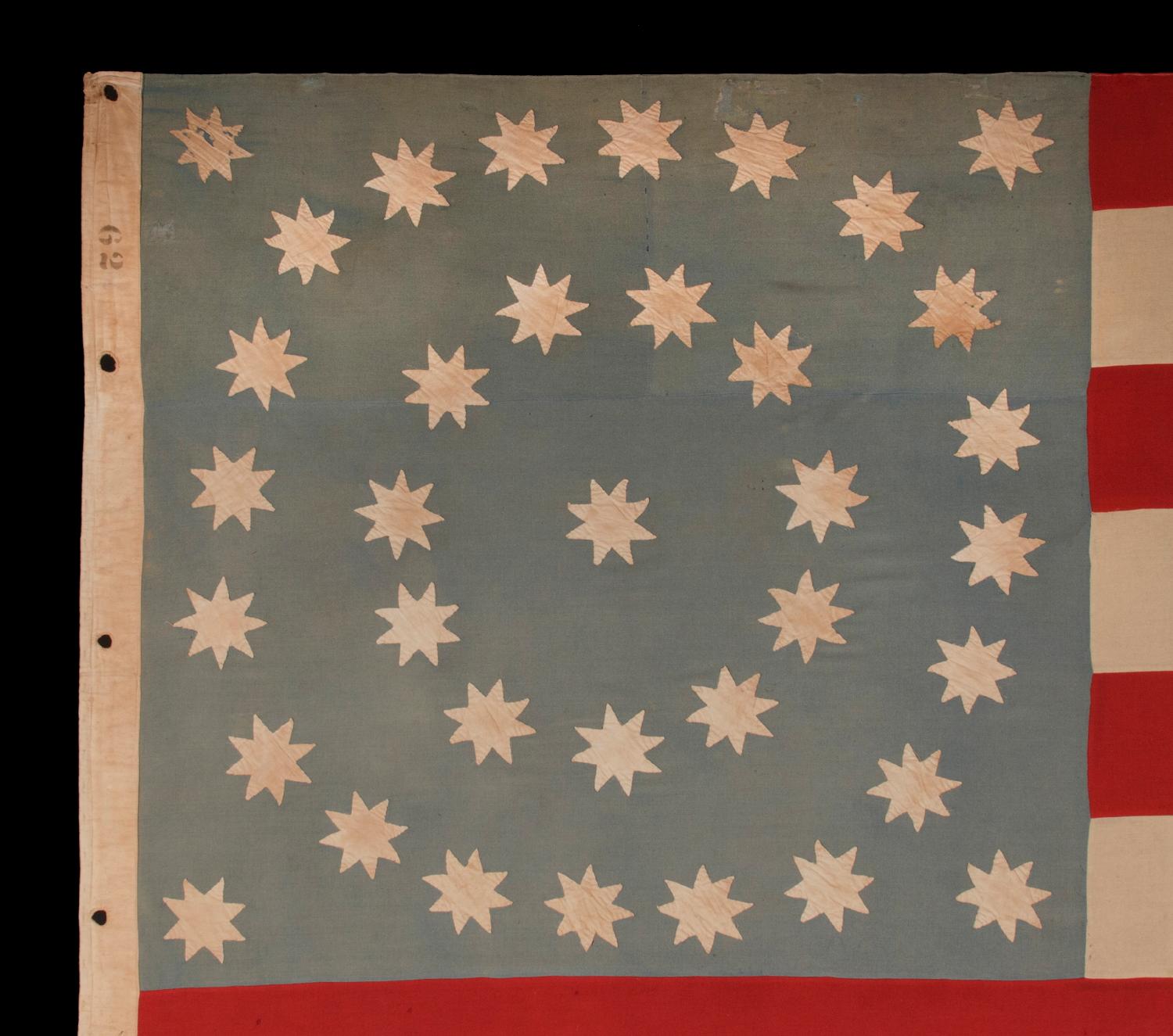 36 EIGHT-POINTED STARS IN MEDALLION CONFIGURATION, ON AN OCEAN BLUE CANTON THAT RESTS ON THE WAR STRIPE; A SPECTACULAR CIVIL WAR PERIOD FLAG FROM THE TINCLAD GUNBOAT 