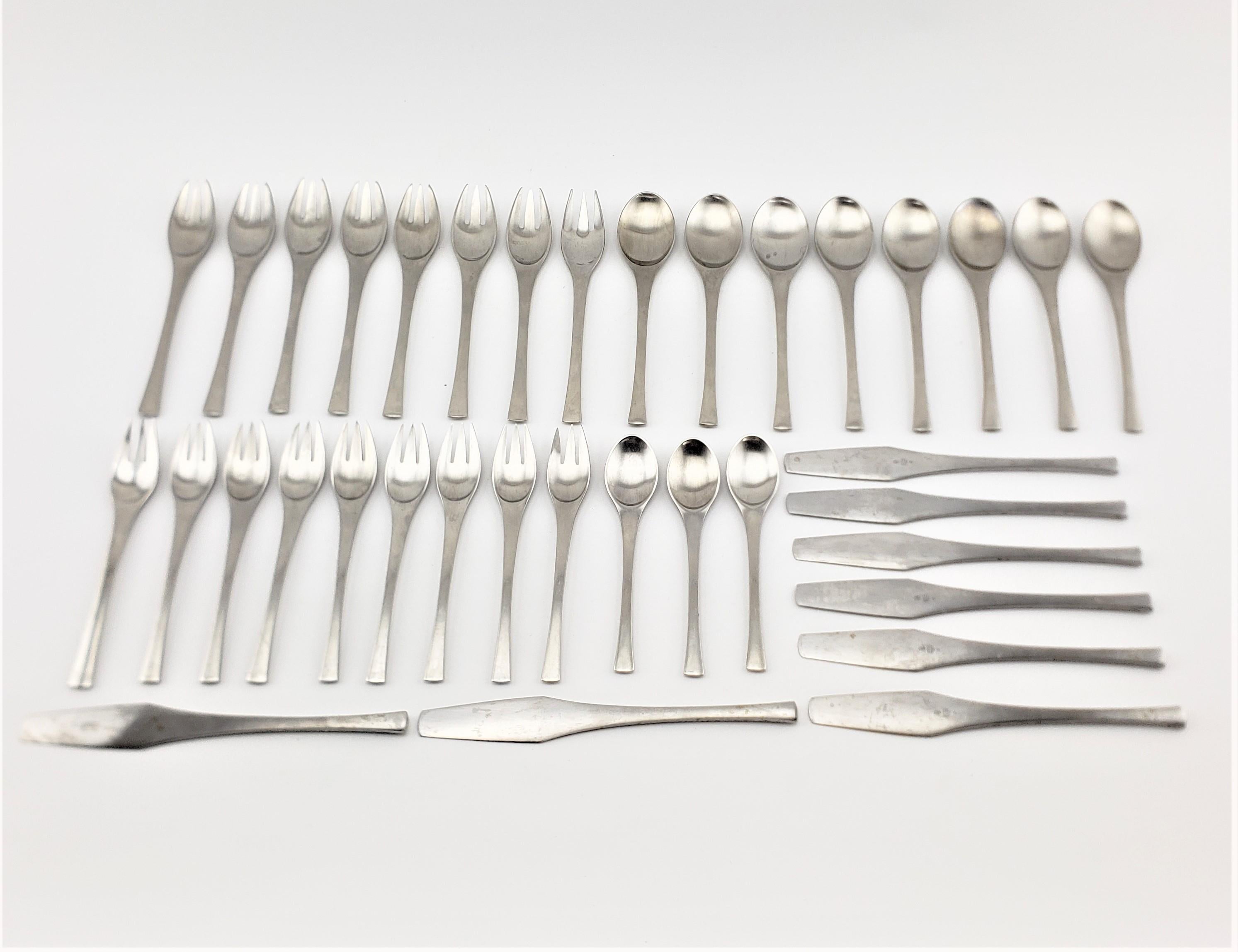 This Mid-Century Modern stainless steel thirty six piece flatware set was made by Dansk in Germany in the Odin pattern. The set is in very good period condition showing only minor surface wear as presented in the photos and consistent with age and