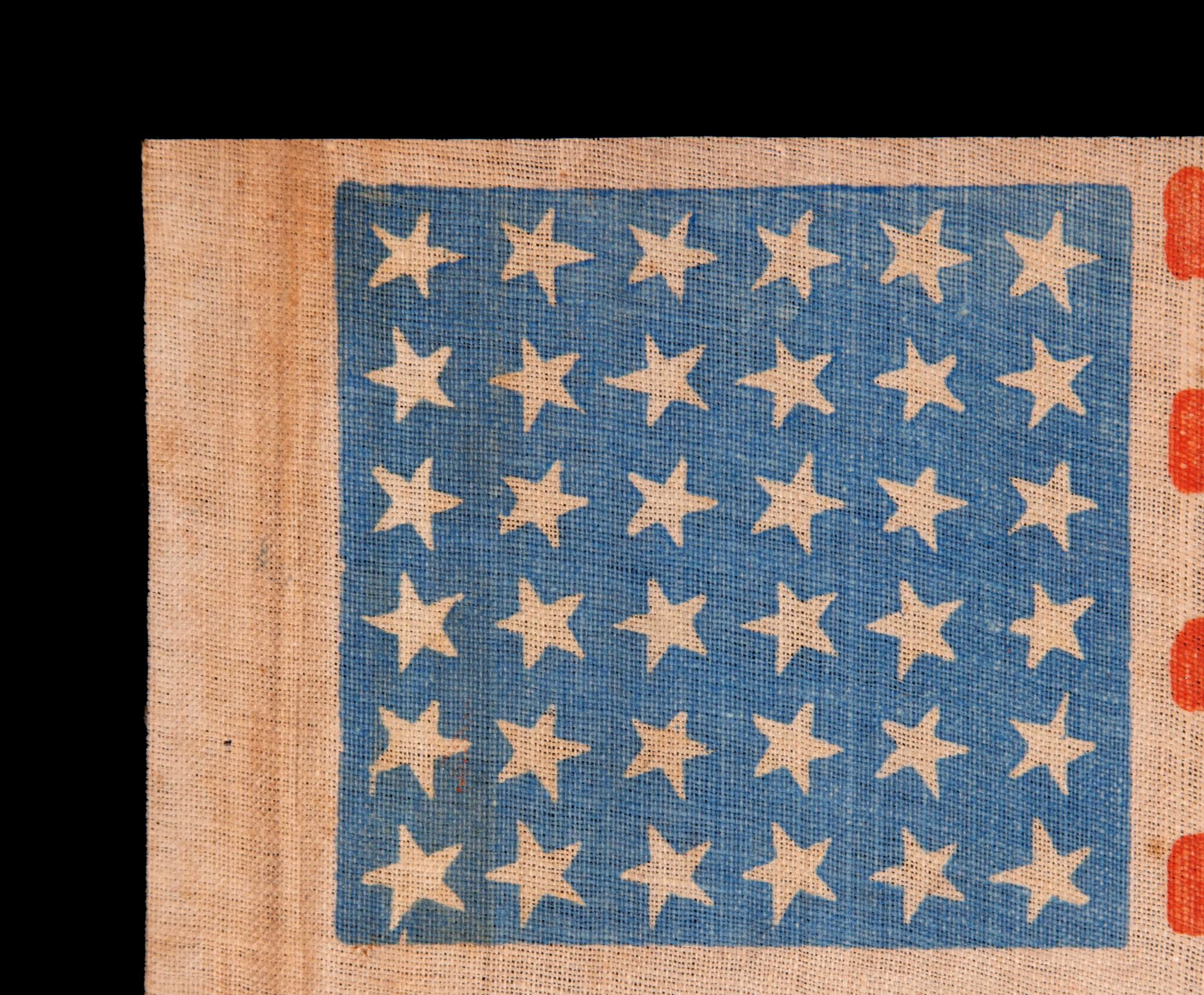 36 STAR ANTIQUE AMERICAN PARADE FLAG WITH CANTED STARS IN DANCING ROWS, ON A BEAUTIFUL, CORNFLOWER BLUE CANTON; CIVIL WAR ERA, NEVADA STATEHOOD, 1864-1867

36 star antique American flag, printed on coarse, glazed cotton. The stars are arranged in