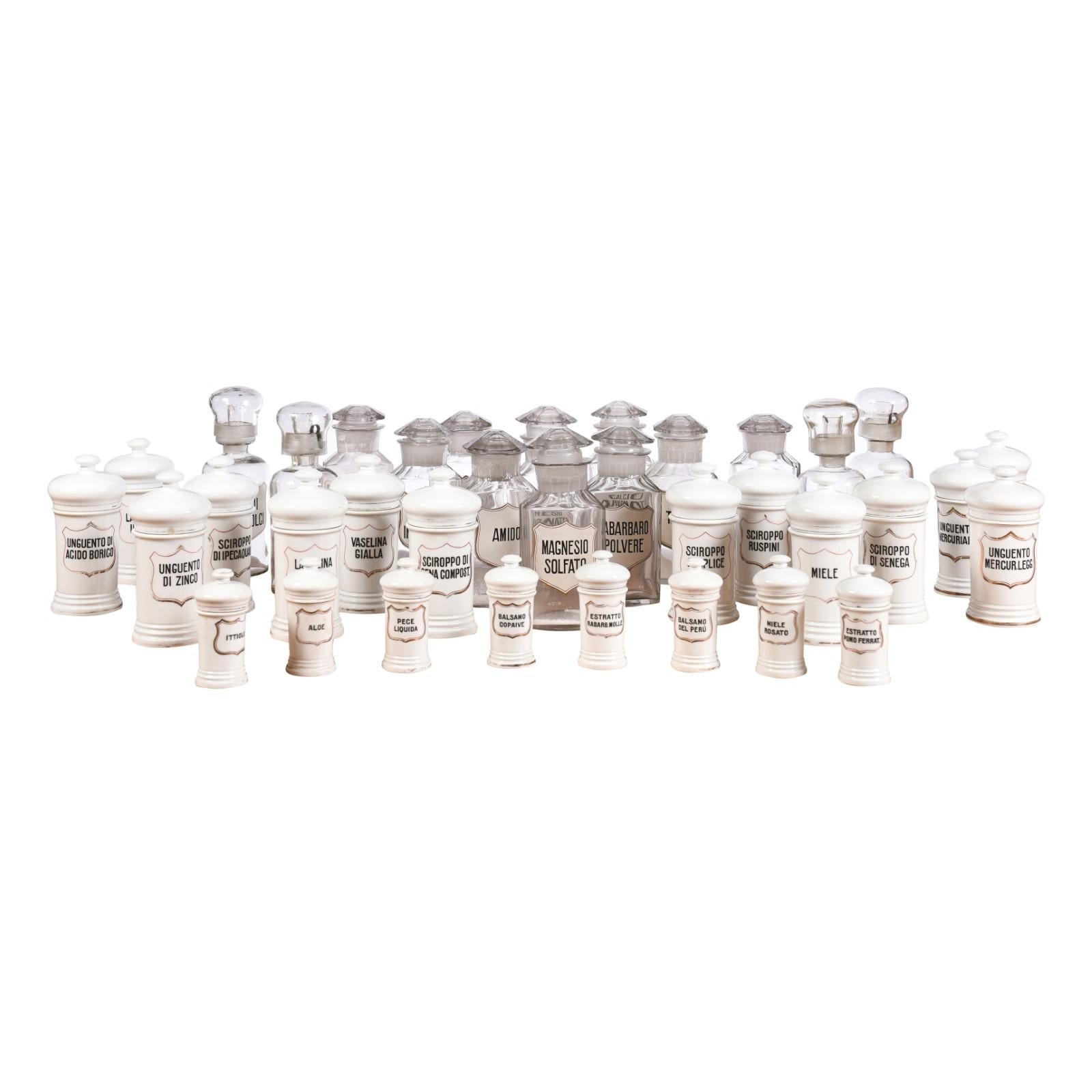 36 Italian pharmacy jars from the 20th century made of either white porcelain or glass and sold individually. Immerse yourself in a piece of history with these charming Italian pharmacy jars, a collection of 36 individual vessels dating back to the