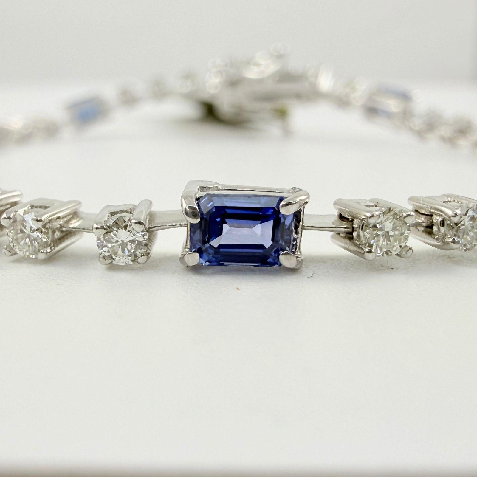 Una refinada fusión de color y brillo, esta pulsera de tenis de 3,60 quilates presenta zafiros azules talla esmeralda y diamantes brillantes redondos alternados, meticulosamente engastados en oro blanco pulido de 14 quilates. Los profundos zafiros