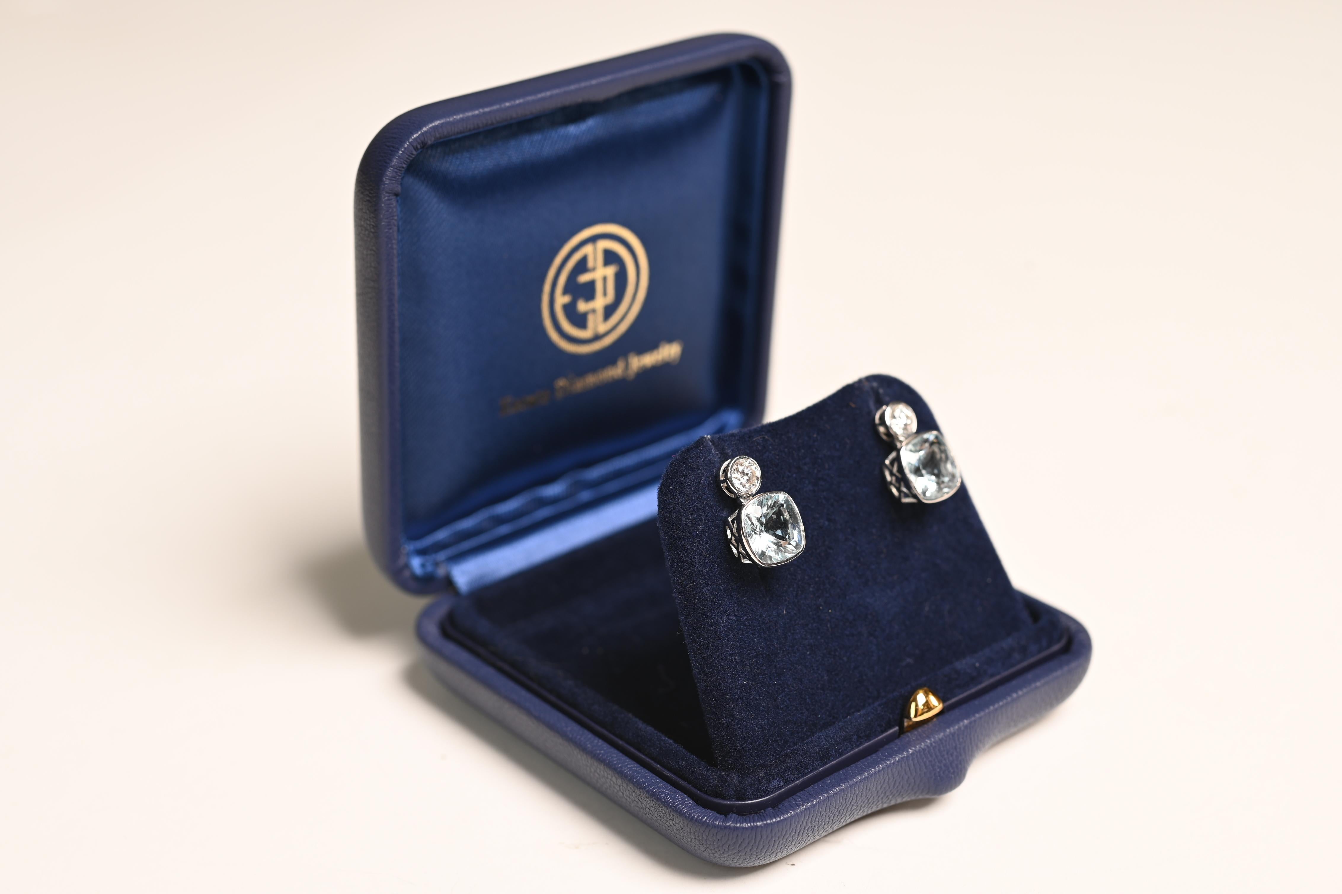 This exquisite pair of drop earrings is crafted in 18k white gold, showcasing the perfect balance of elegance and sparkle. Each earring features a cushion-cut aquamarine, with an approximate total weight of 3.6-carats, offering a captivating,