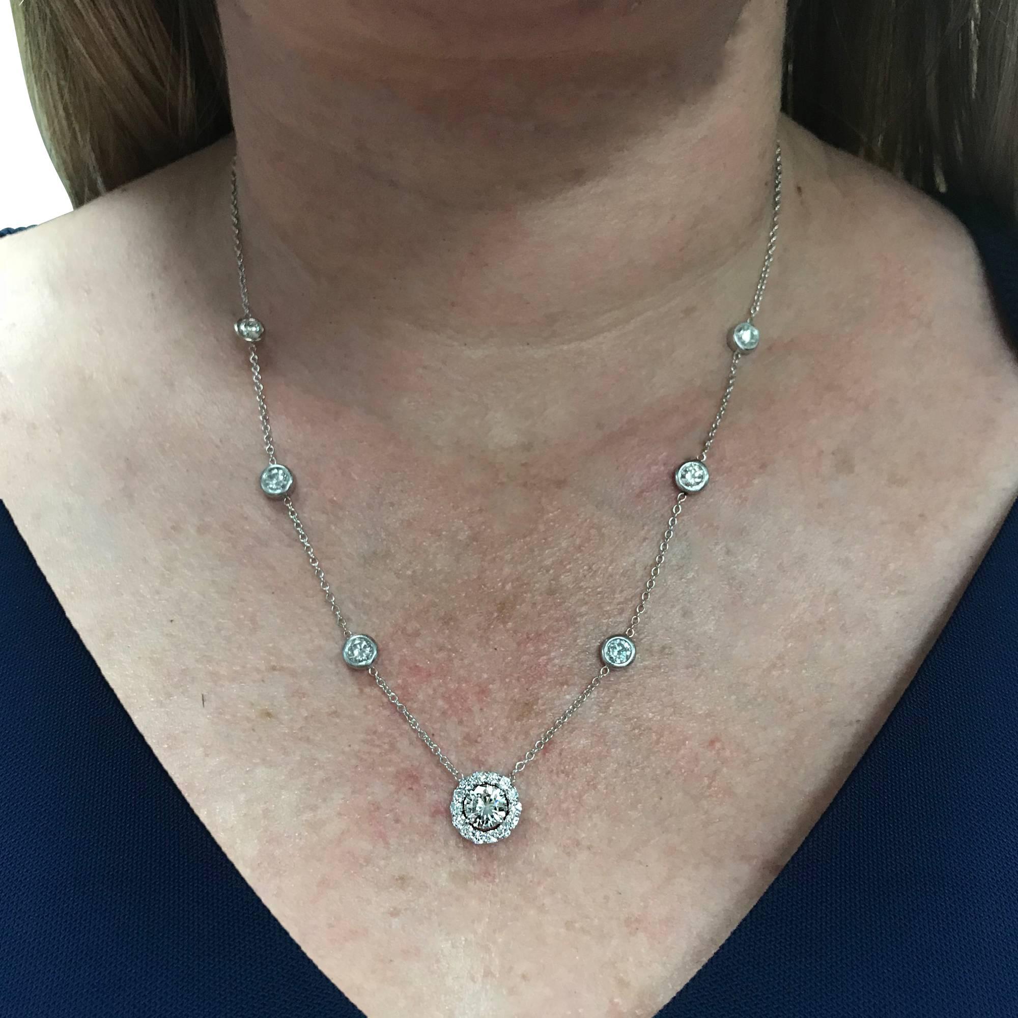 Stunning 18K White gold necklace containing a round brilliant cut diamond weighing approximately 1.12cts K color and VS clarity surrounded by 15 round brilliant cut diamonds weighing approximately .48cts J color and VS-SI clarity. The necklace is