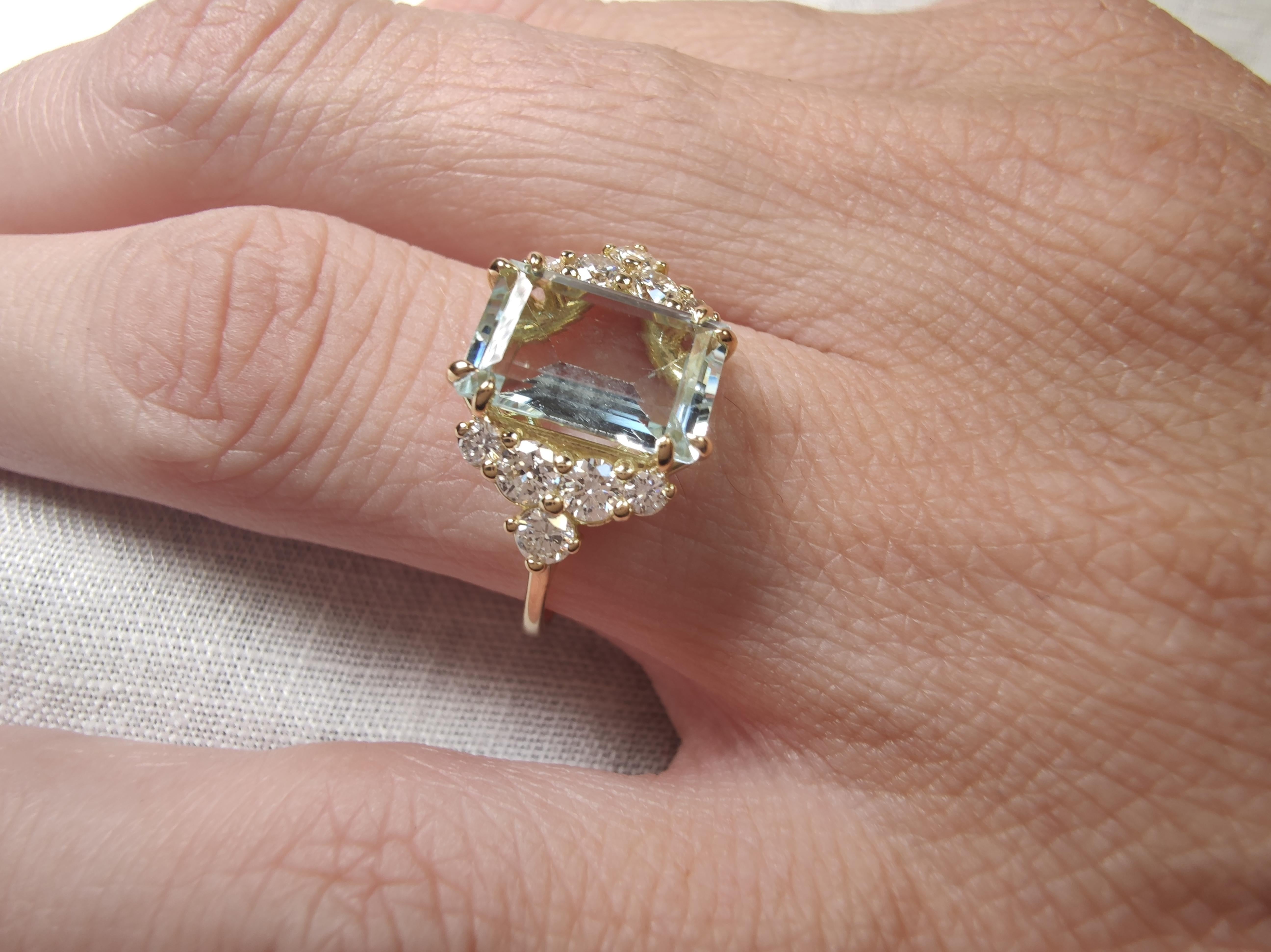 This sophisticated contemporary ring for women is crafted in solid 18K yellow gold, featuring a stunning 3.60-carat emerald-cut aquamarine, accompanied by a harmonious arrangement of eight natural brilliant-cut diamonds. Elegant and radiant, this