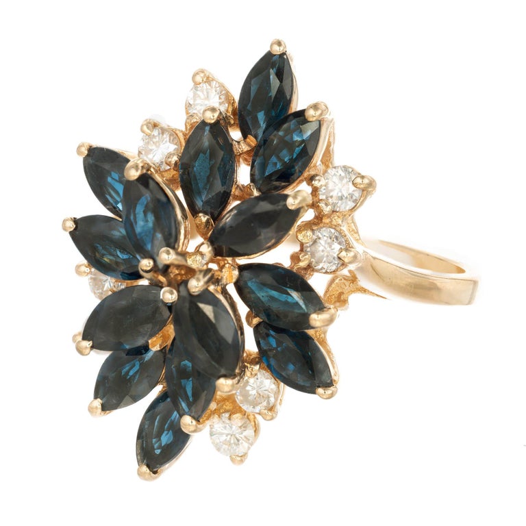 Mid-Century marquise sapphire and round diamond 14k Yellow Gold Cocktail Cluster Ring.

14 Marquise cut dark blue sapphire, Approximate 3.36 carats 
8 Round H-I SI2 diamonds, Approximate .24 carats 
Size 7 ¾ and sizable 
14k Yellow Gold 
Stamped: