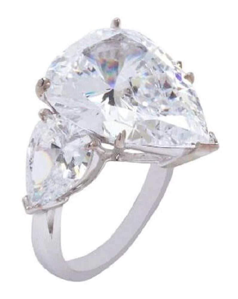 An exquisite ring composed by a main stone with a 3 carat center stone plus two side pear cut diamonds of approximately 0.30 carats each 

