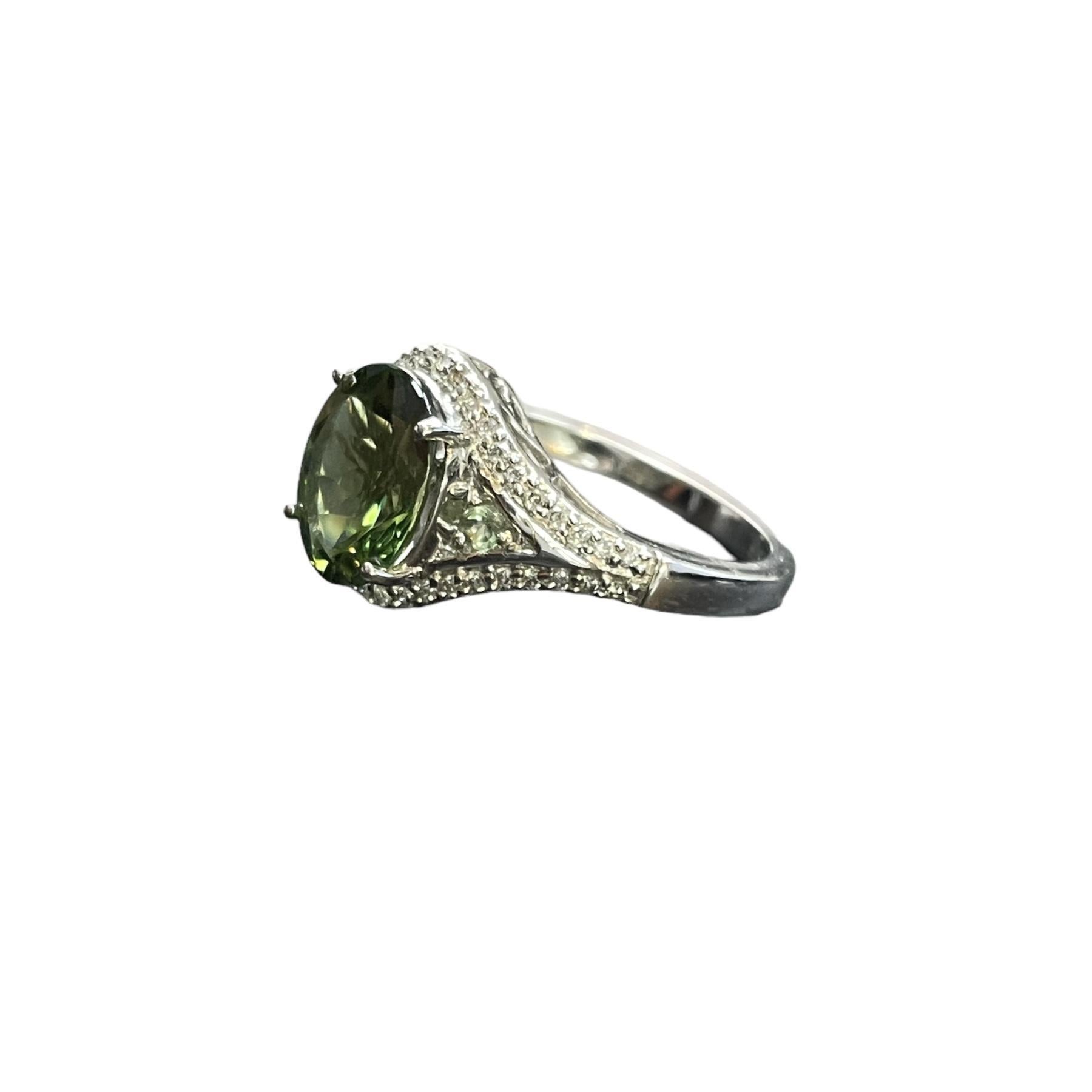 Elevate your jewelry collection with this tsavorite and Diamond Ring, a true testament to sophistication and style. 
Crafted in lustrous 14K white gold, this ring showcases a mesmerizing 3.60-carat tsavorite gemstone surrounded by a halo of dazzling