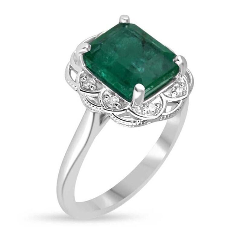Dieser florale Verlobungsring aus Weißgold mit 3,60 TCW, 14 Karat, grünem Smaragd und Diamanten, ist eine exquisite Feier der Liebe und der Kunstfertigkeit und fängt die Essenz zeitloser Romantik, der Natur und raffinierter Handwerkskunst ein. Sein