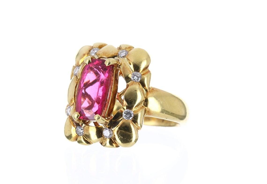 Featured is an ultra chic, high fashion, 3.60 carat rubellite and diamond cocktail ring 18K. Dexterously handcrafted in gleaming 18k solid, yellow gold. This ring features a genuine AAA+ quality rubellite. This stone is beautifully saturated and has