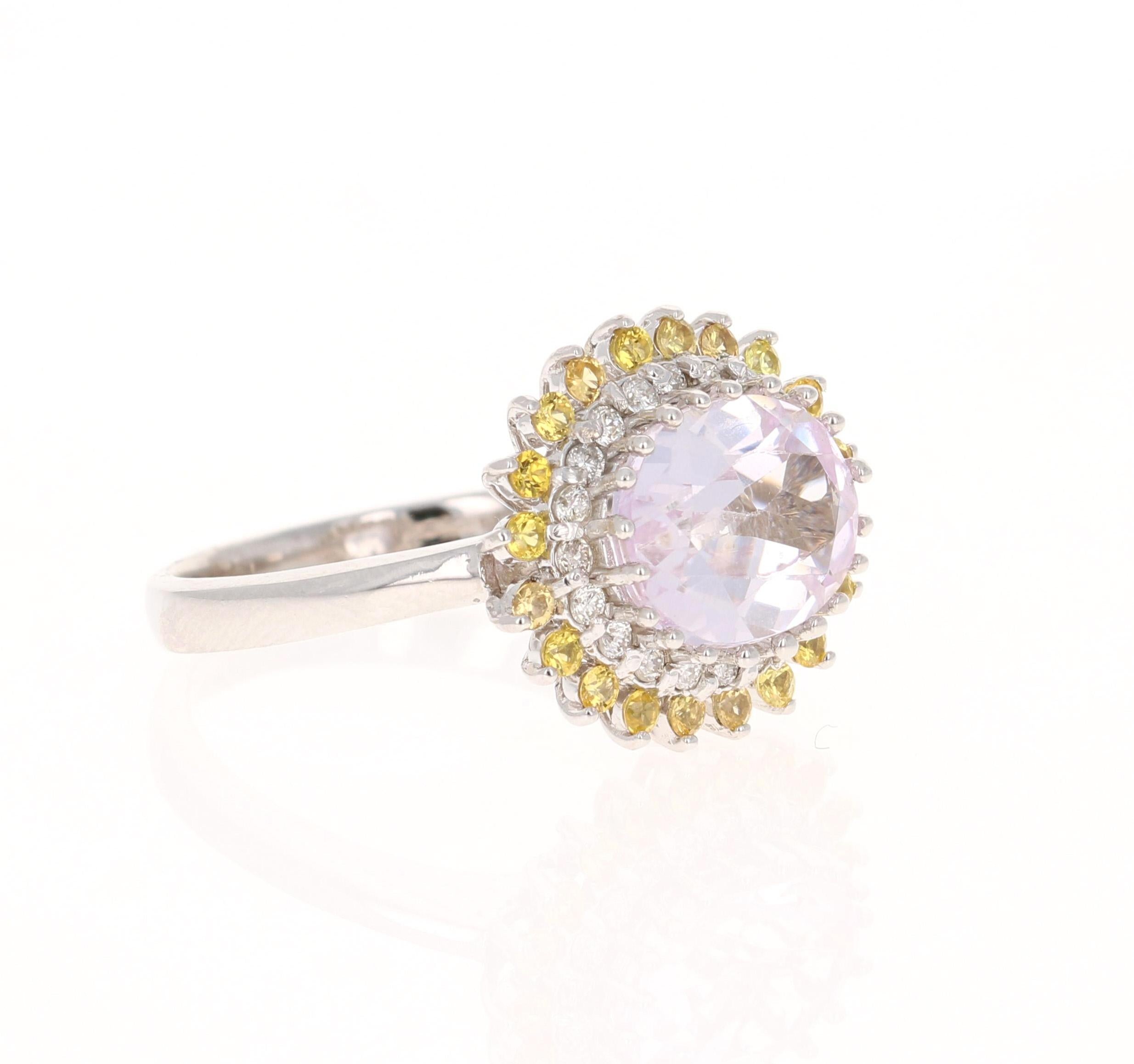 This ring has a Oval Cut Light Pink Kunzite that weighs 3.02 carats and measures at 8 mm x 10 mm. It is surrounded by 20 Yellow Sapphires that weigh 0.39 carats adn 20 Round Cut Diamonds that weigh 0.21 carats. (Clarity: VS, Color: H)

The ring is