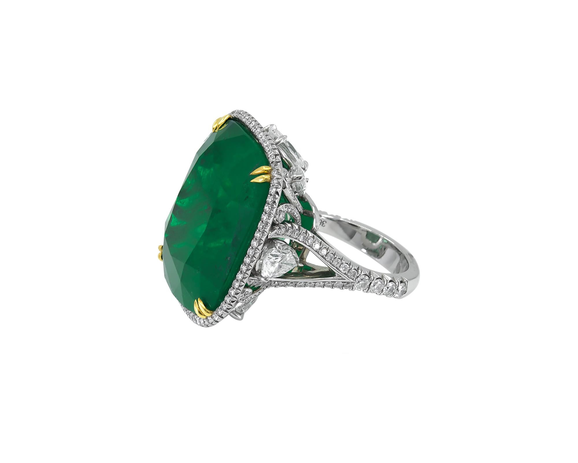 A magnificent ring comprising of a cushion emerald and diamonds. The emerald is of Colombian origin weighing 36.29 carats total. The emerald is set in a mounting beautifully decorated with 4 marquise-shaped diamonds weighing 1.31 carats, 4