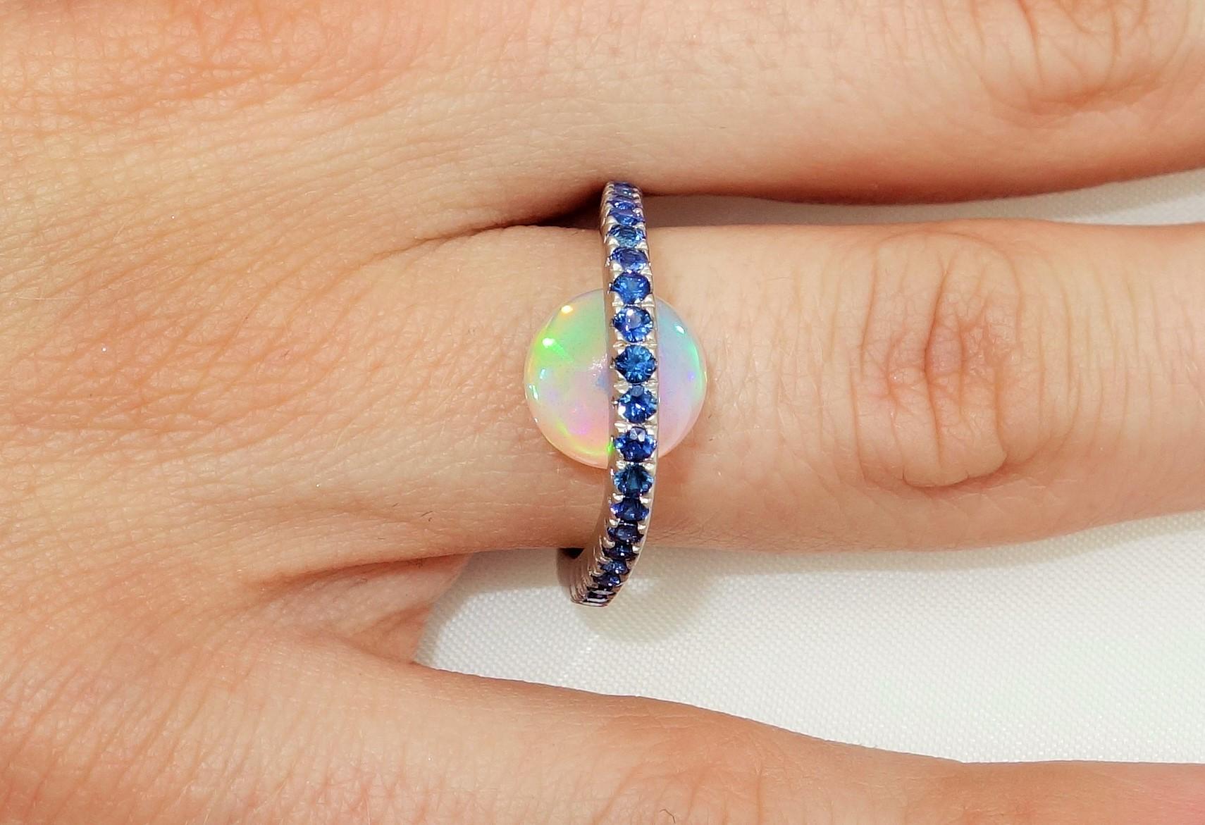 Top of ring set with Blue Sapphires, featuring a 3.63 Carat Ethiopian Opal below; Blue Sapphires approx. .70tctw; Sterling Silver Tarnish-resistant Rhodium mounting Ring size 6, we offer ring re-sizing. More fabulous in person...A Striking