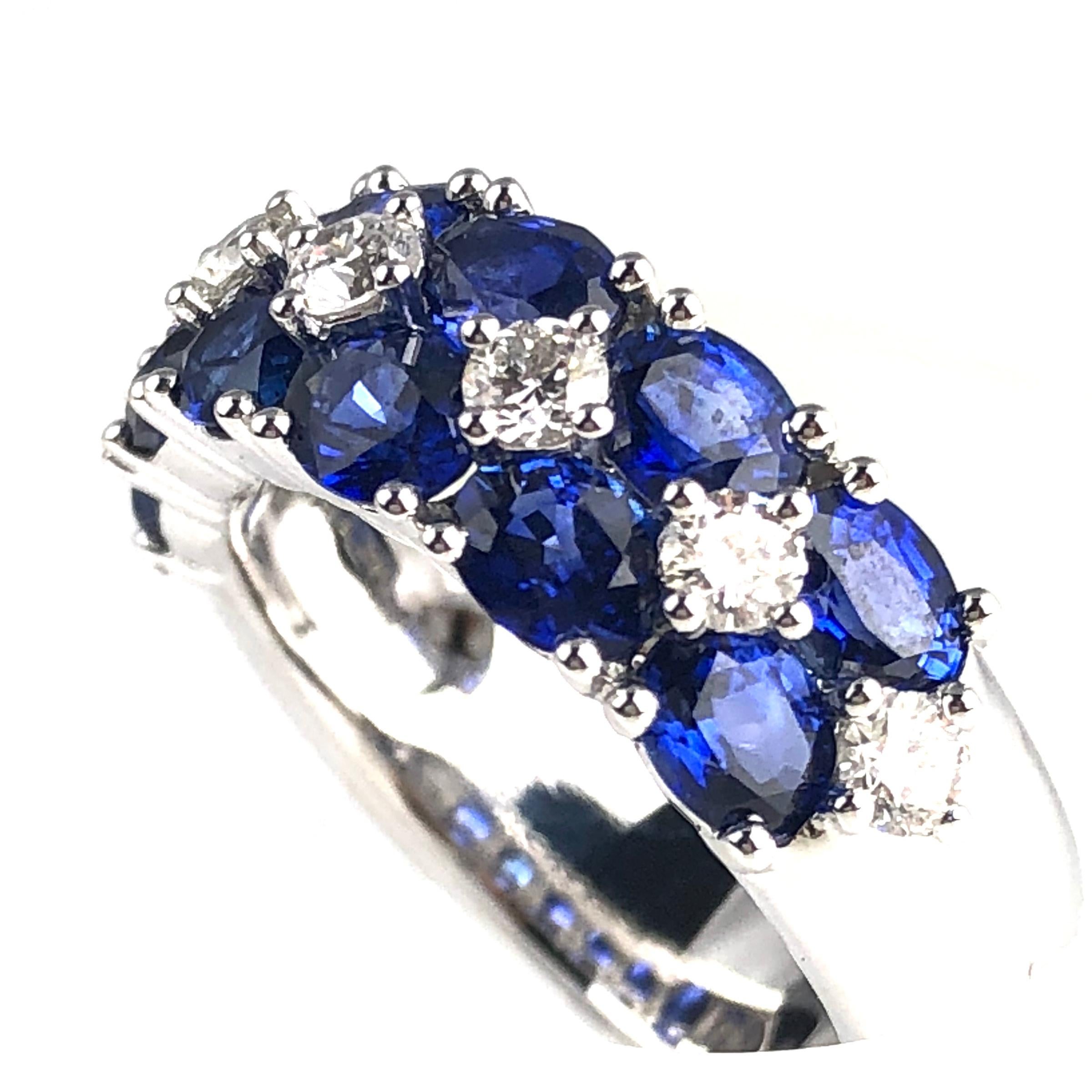 This gorgeous handcrafted ring features 12 oval cut vivid blue sapphires tucked among 0.52 carats white diamonds. The layered design extends across the full width of the band.

This ring can be professionally sized to your specification, at no