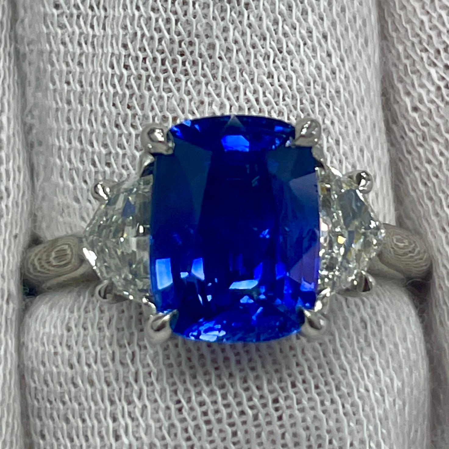 This is a cornflower blue cushion sapphire mounted in an elegant platinum ring with 0.69Ct of brilliant white diamonds. Suitable for any occasion!