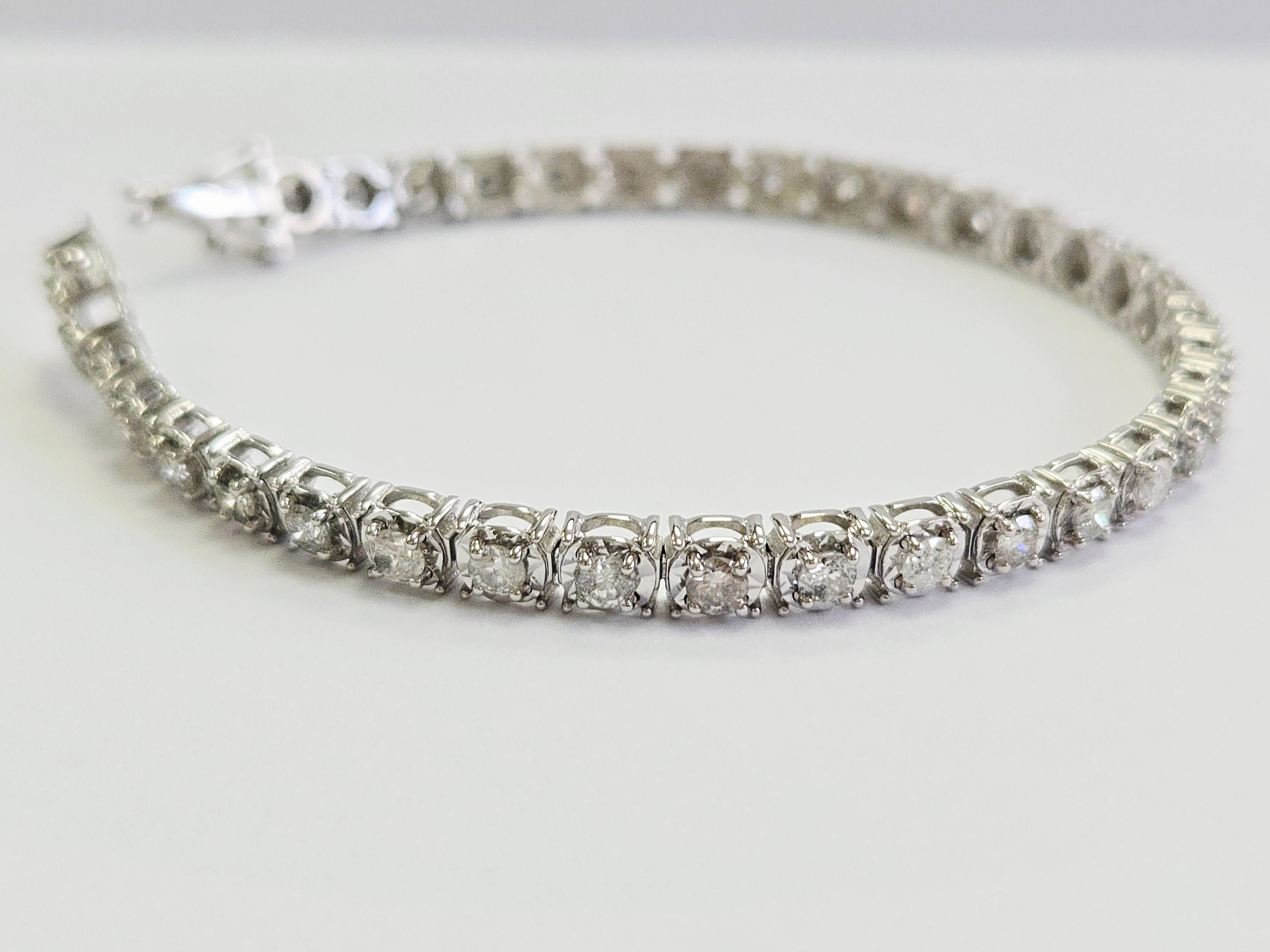 Descubre la elegancia atemporal con esta exquisita pulsera de tenis ilusión de diamantes de 3,64 quilates, meticulosamente elaborada en oro blanco de 14 quilates. Diseñada para cautivar y elevar cualquier conjunto, esta pulsera combina a la