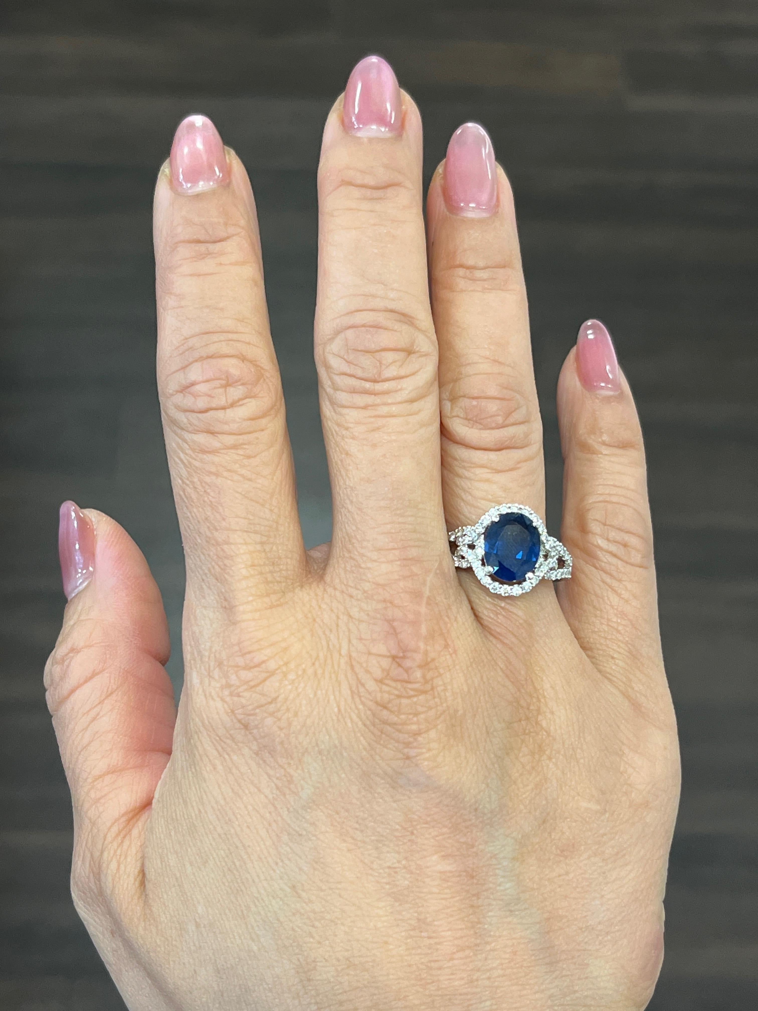 This gorgeous 18k white gold ring is set with a natural blue sapphire weighing 3.02 ct. It is surrounded with 66 round diamonds with a carat weight of 0.62. The diamonds boast a color or G/H and is SI1/SI2 in clarity. A beautiful ring to add to any