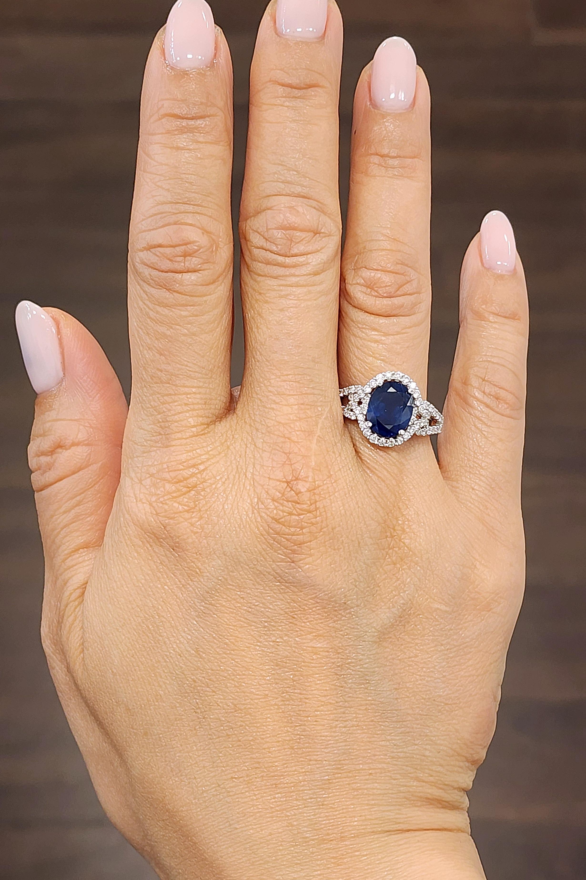 This gorgeous 18k white gold ring is set with a natural blue sapphire weighing 3.02 ct. It is surrounded with 66 round diamonds with a carat weight of 0.62. The diamonds boast a color or G/H and is SI1/SI2 in clarity. A beautiful ring to add to any