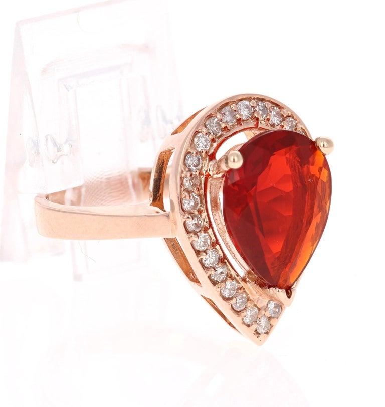The Fire Opal is 3.20 Carats and is surrounded by 28 Round Cut Diamonds that weigh 0.45 Carats. The total carat weight of the ring is 3.65 Carats. 

It is set in 14K Rose Gold and is approximately 6.6 grams. 

The ring size is 7 and can be re-sized