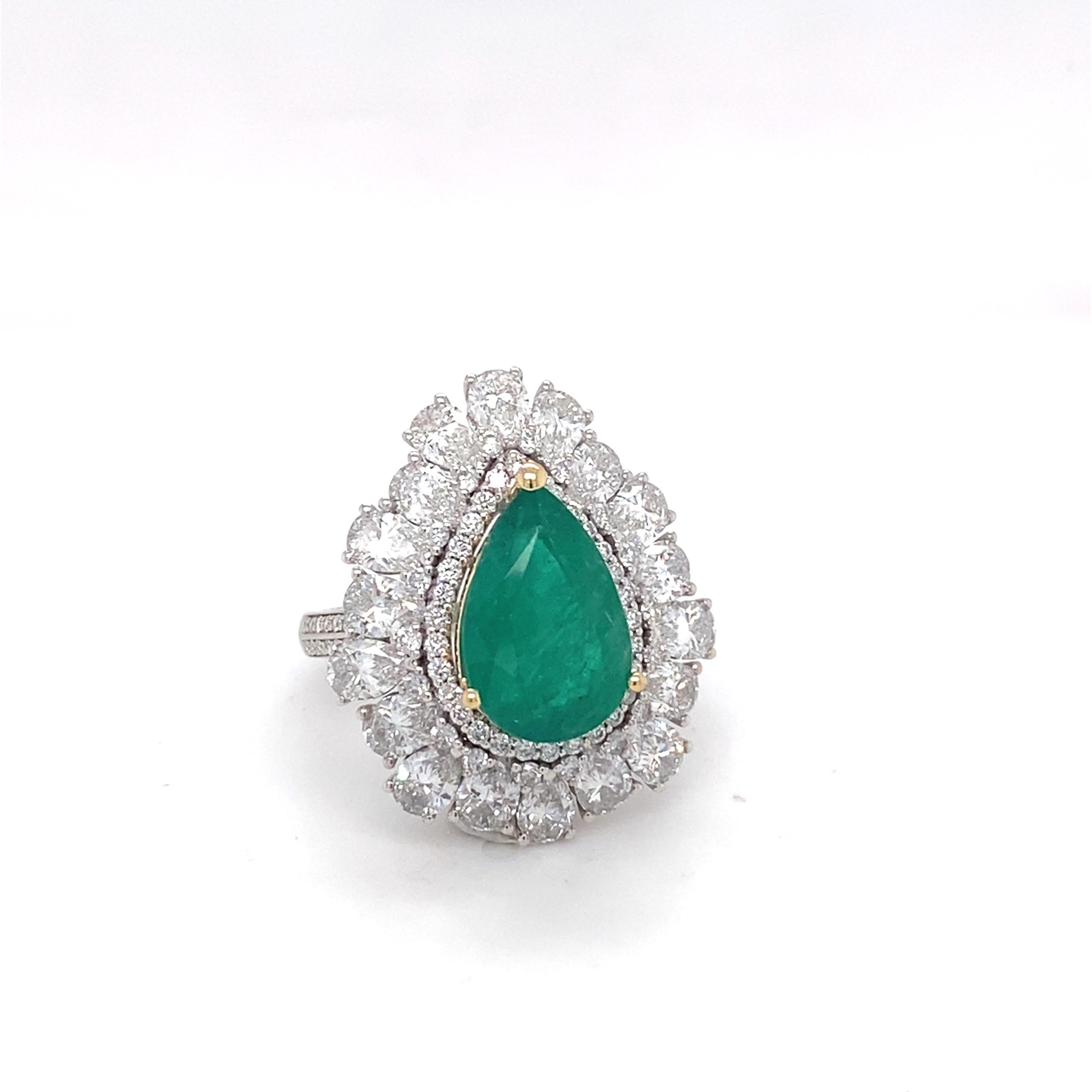 Make a bold statement with this exquisite Emerald Diamond cocktail ring, expertly crafted in 18K white gold. The pear-cut emerald is beautifully framed by a combination of pear and round natural diamonds, while a diamond-pave band adds extra