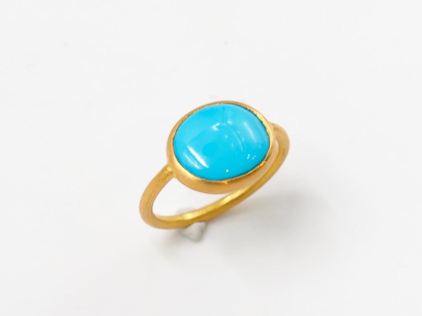 This simple ring by Scrives is composed of a large turquoise cabochon of 3.65 cts. 
The stone is set in a 22kt closed gold setting.
This turquoise is natural with a vibrant and strong colour. It has natural & typical small inclusions. The stone