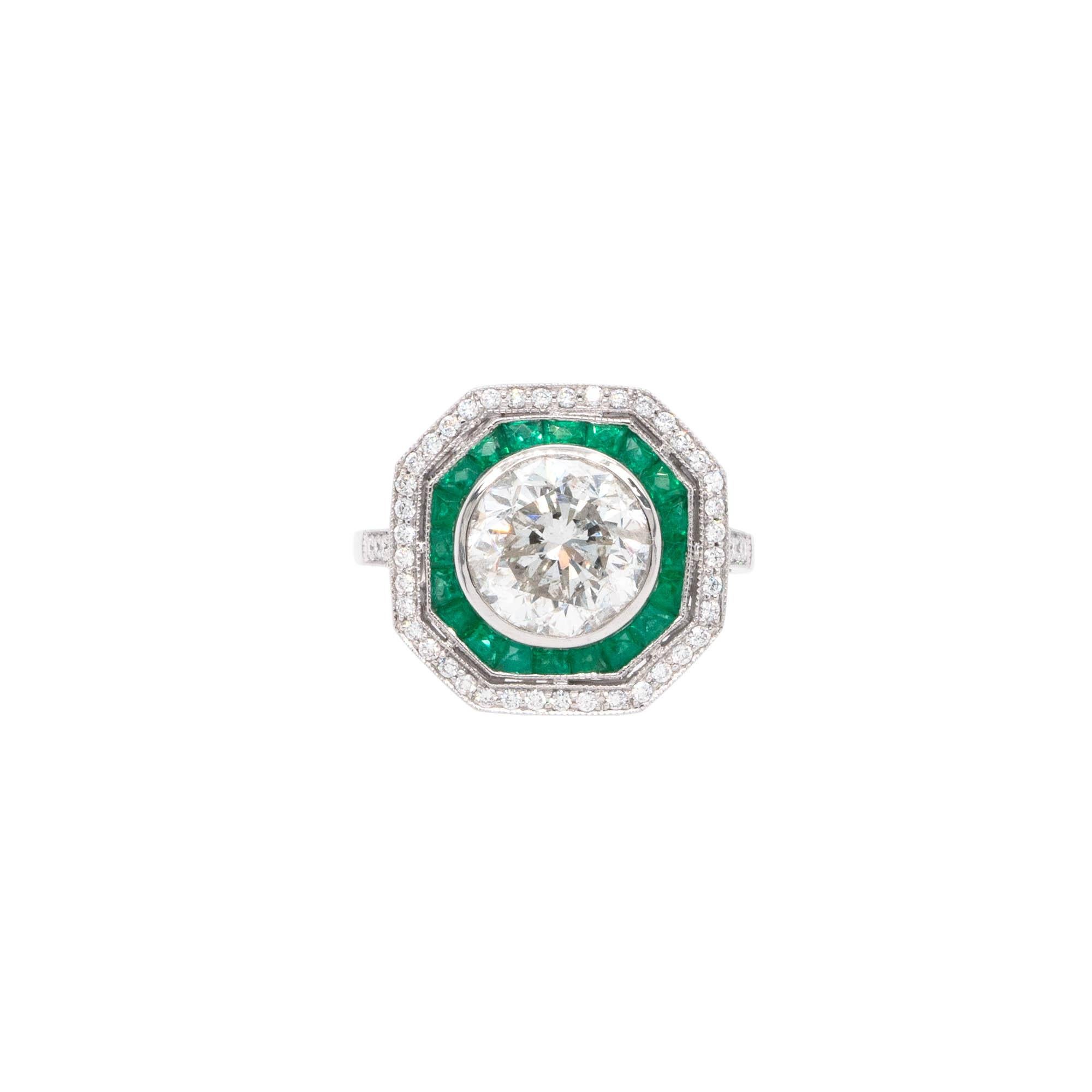 This is a platinum ring featuring a 3.66ct natural round brilliant cut diamond, with a G/H color and I1 clarity. It also has 0.31ctw of round cut natural diamonds that are G/H in color and VS in clarity, as well as 0.65ctw of emerald gemstones. The