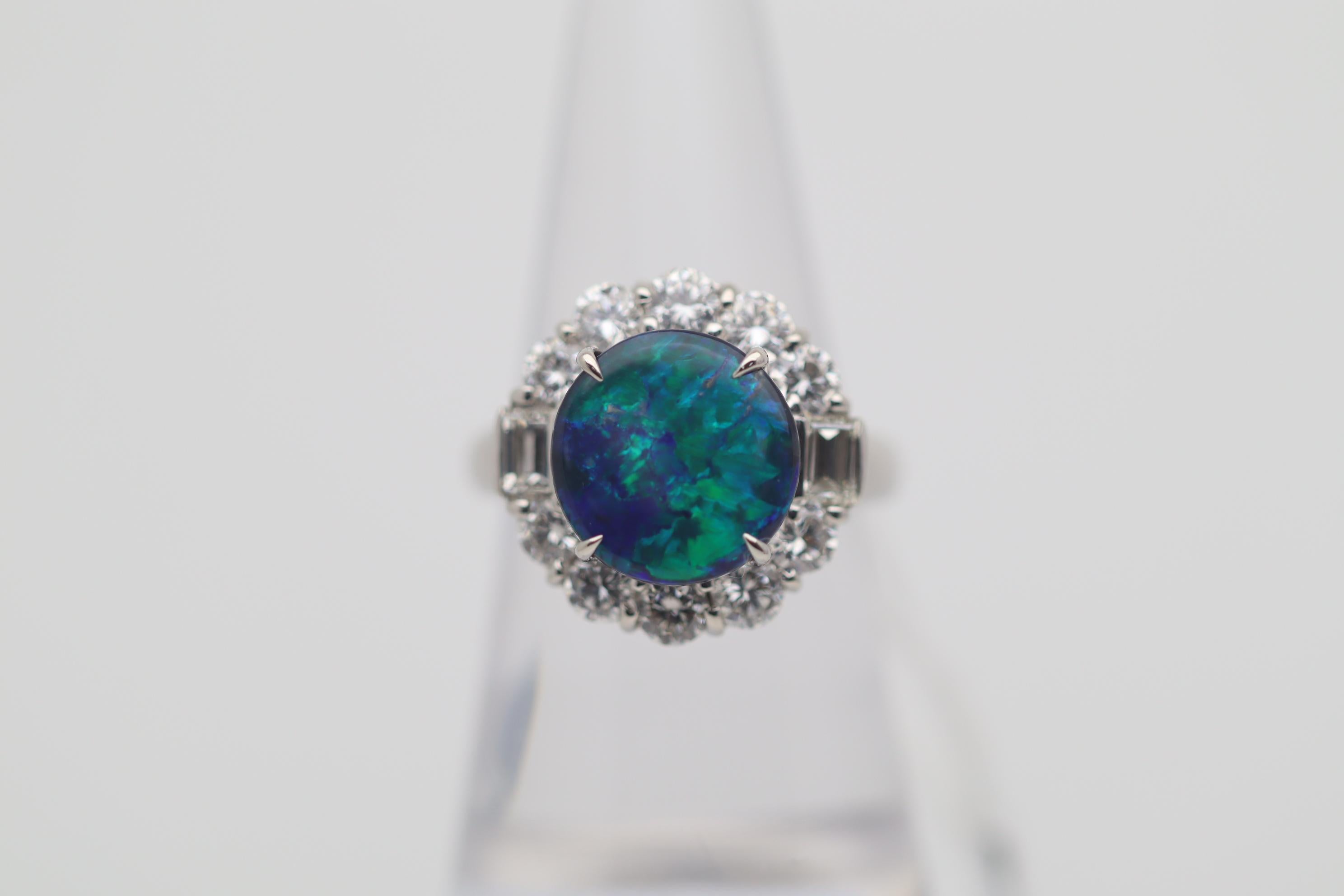 A superb true gem quality Australian black opal takes center stage. The gem opal weighs 3.67 carats and has some of the best play-of-color we have seen this year. Extremely bright and lively flashes of green and blue roll across the deep black opal