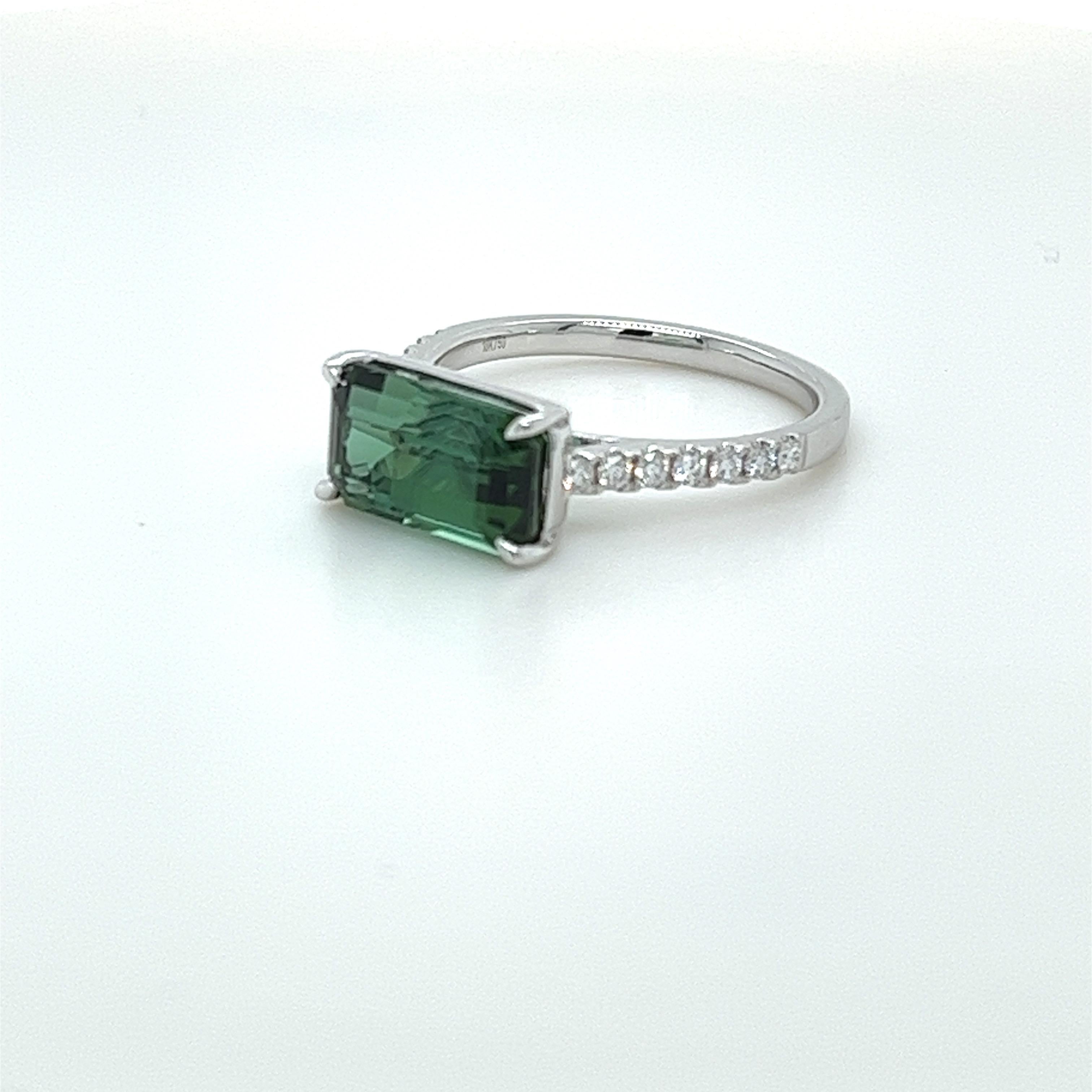 Emerald Cut Green Tourmaline weighing 3.68 carats
Measuring (11.2x6.6) mm
14 pieces of round diamonds weighing .21 carats
GH-Si1 quality
Set in 18 karat white gold ring
3.23 grams
Very fashionable everyday ring