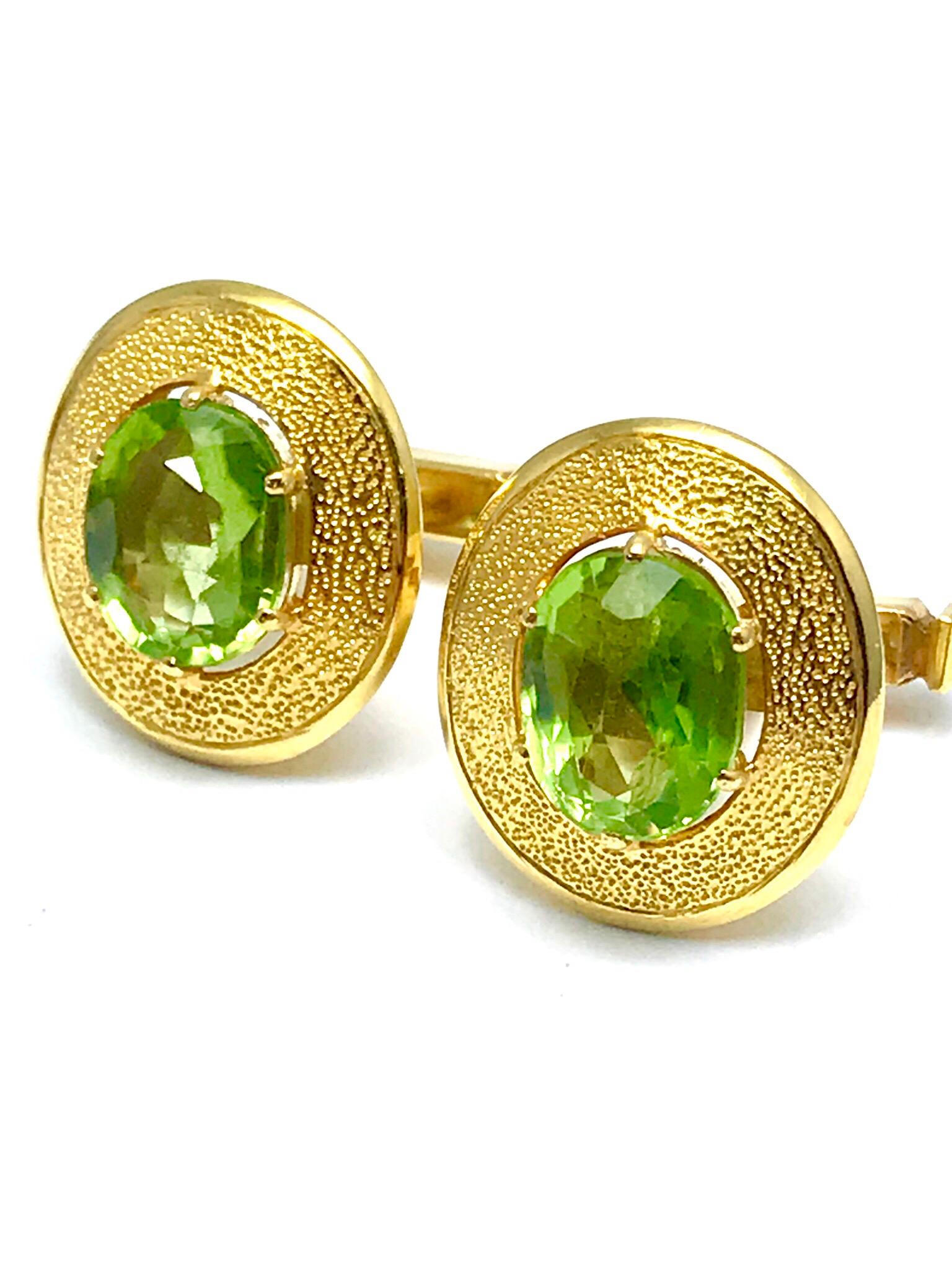 A fabulous pair of Oval faceted Peridot  and 18 karat yellow gold cufflinks.  The two Peridot have a total weight of 3.68 carats, they are prong set with a textured gold frame and a toggle back.  Offered by Charles Schwartz & Son