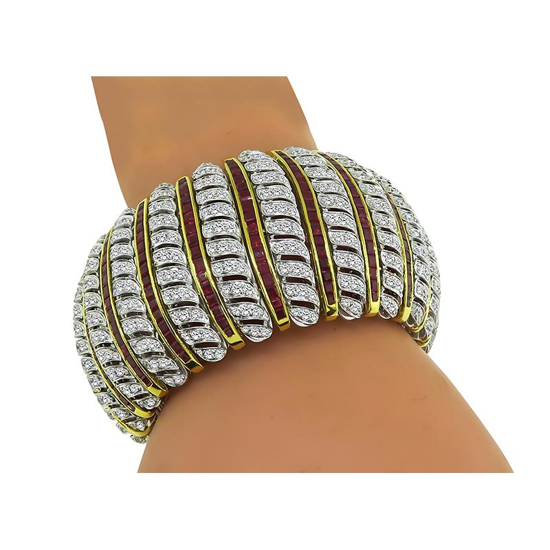This is an elegant 18k yellow and white gold bracelet. The bracelet is set with sparkling round cut diamonds that weigh approximately 19.57ct. The color of these diamonds is G with VS clarity. The diamonds are accentuated by lovely square cut rubies