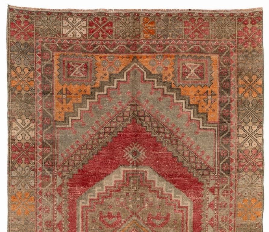 This gorgeous vintage hand-knotted Turkish area rug. It is made of soft, lustrous sheep's wool on wool foundation, is in very good condition, sturdy and clean as a brand new rug. It features a well-drawn geometric design with a medallion at its