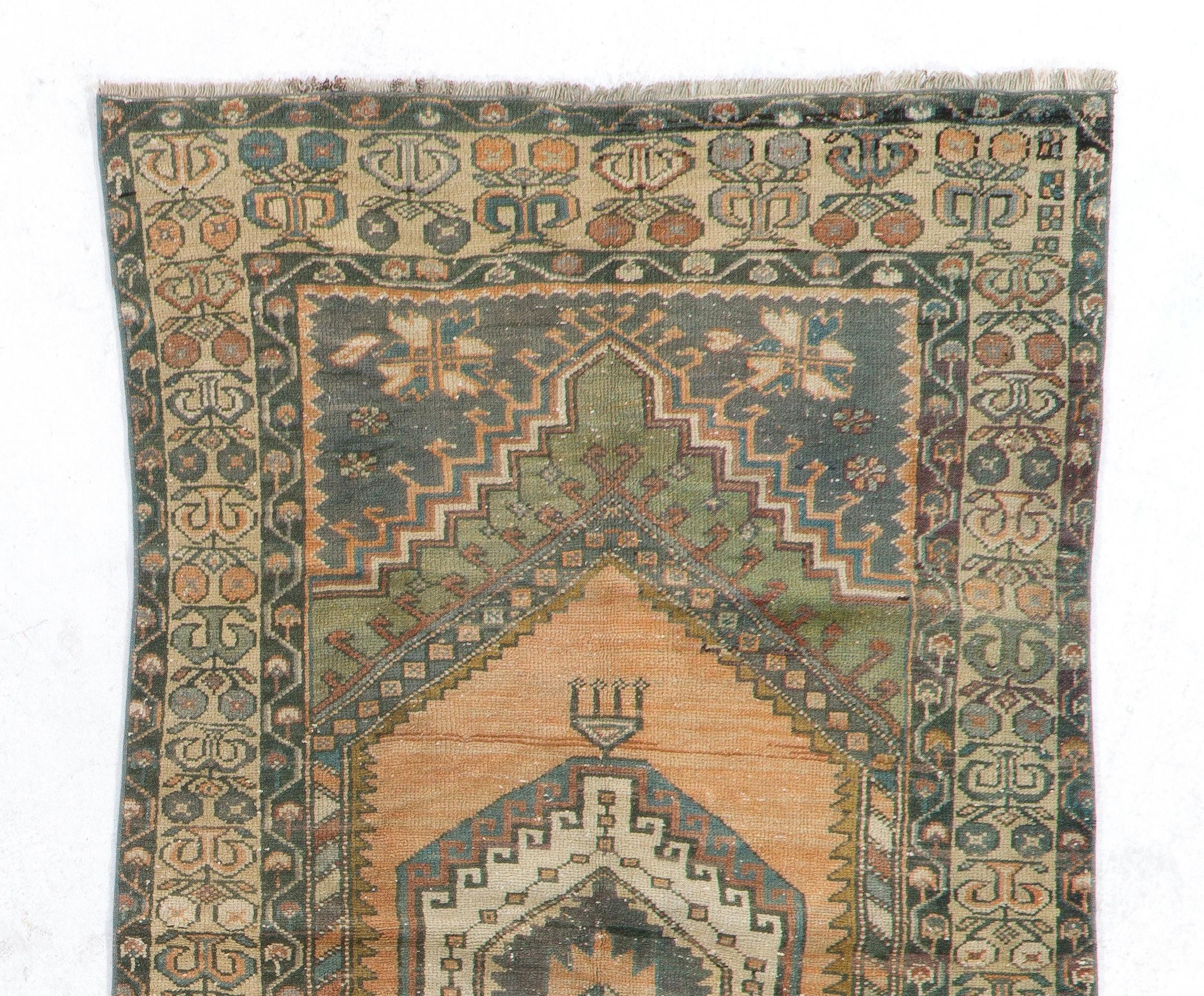 This vintage Central Anatolian rug features two linked medallions in deep-saturated gold with cross-shaped motifs inside against a plain field in soft muted soft red. The corner-pieces in charcoal gray are decorated with large, elongated palmettes.