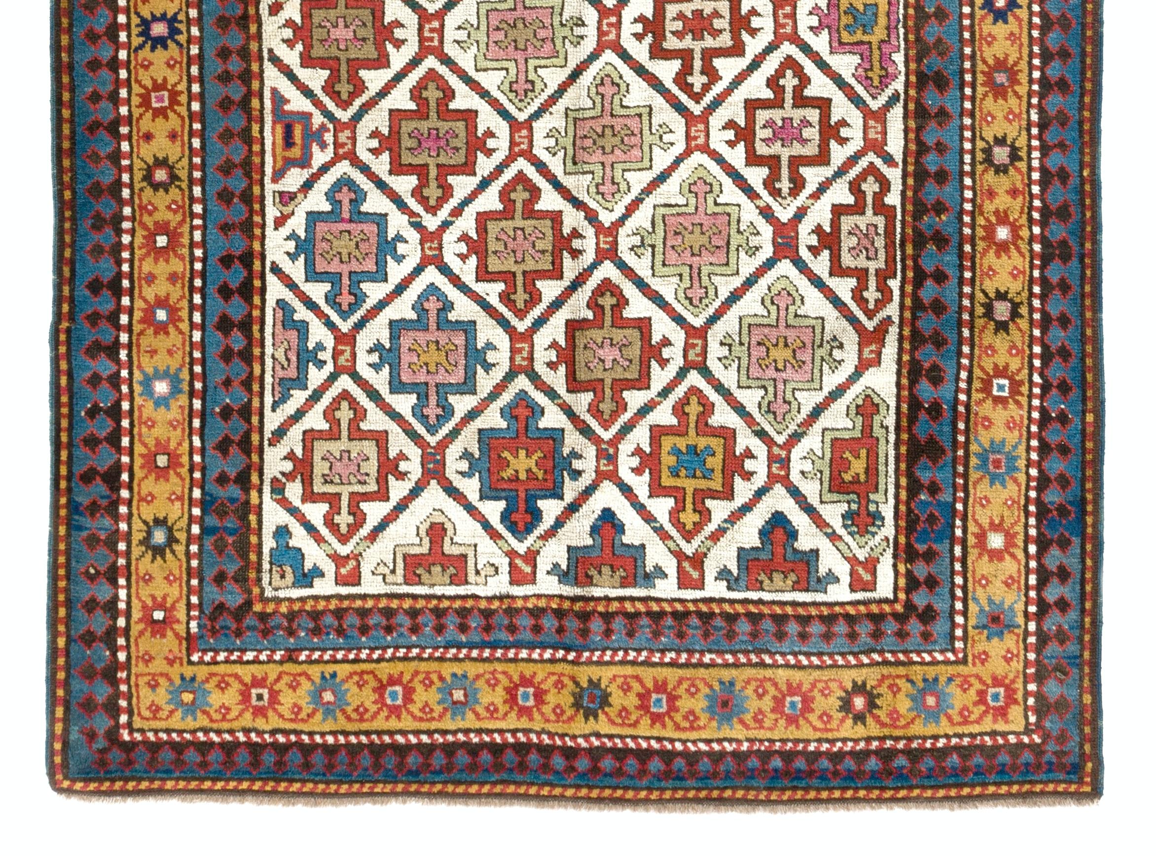 A rare and early Karabagh long rug from the first quarter of the 19th century featuring an all-over lattice work design with integrated shield and cross motifs in a subtle color palette of soft pink, sage green, beige, rust, navy blue and cerulean