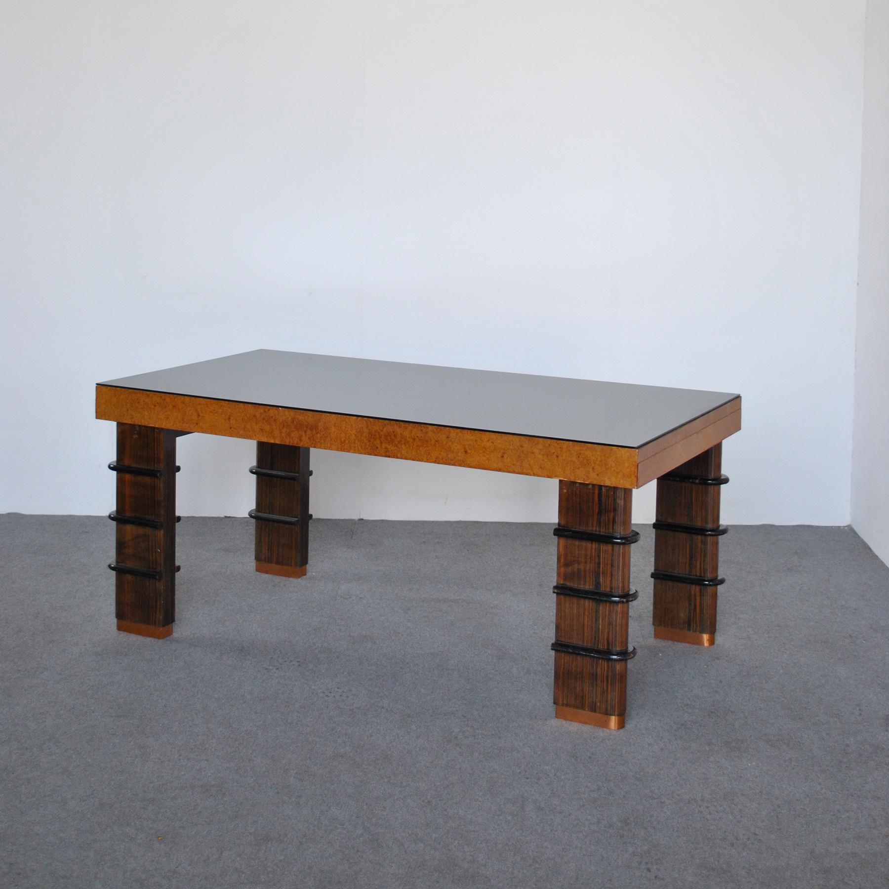 Refined table with black glass top and light briar, the legs are embellished with frames that surround them and with copper terminals, Art Deco style, from the late 40s.