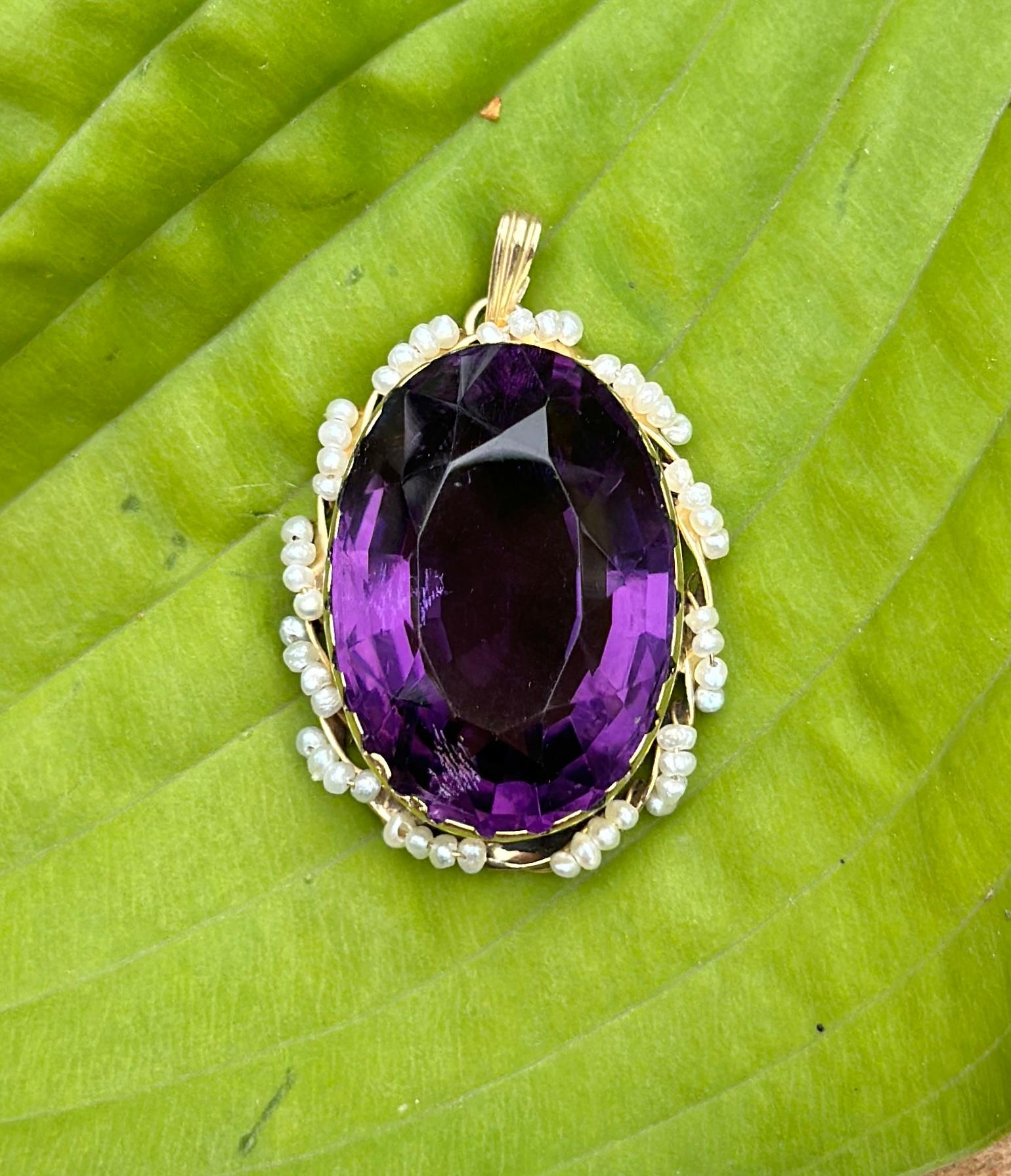 THIS IS A STUNNING 37 CARAT OVAL FACETED AMETHYST AND PEARL LAVALIERE PENDANT WITH THE MOST GORGEOUS MONUMENTAL NATURAL OVAL FACETED AMETHYST GEM SET IN A CUT DOWN COLLET ADORNED WITH SEED PEARLS IN 14 KARAT YELLOW GOLD.  THIS IS A DRAMATIC ROMANTIC