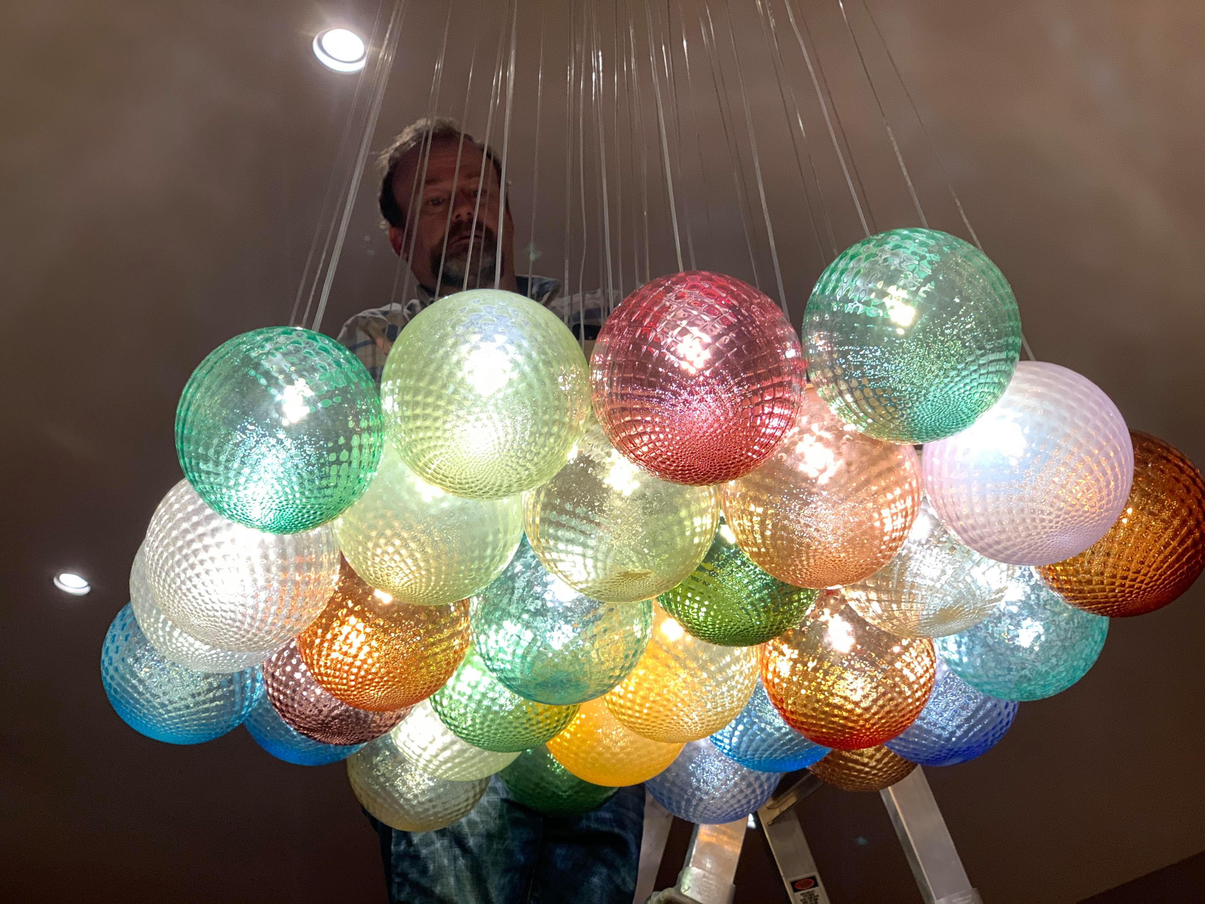 Contemporary 37 lights ceiling chandelier, with colored transparent Murano glass spheres For Sale